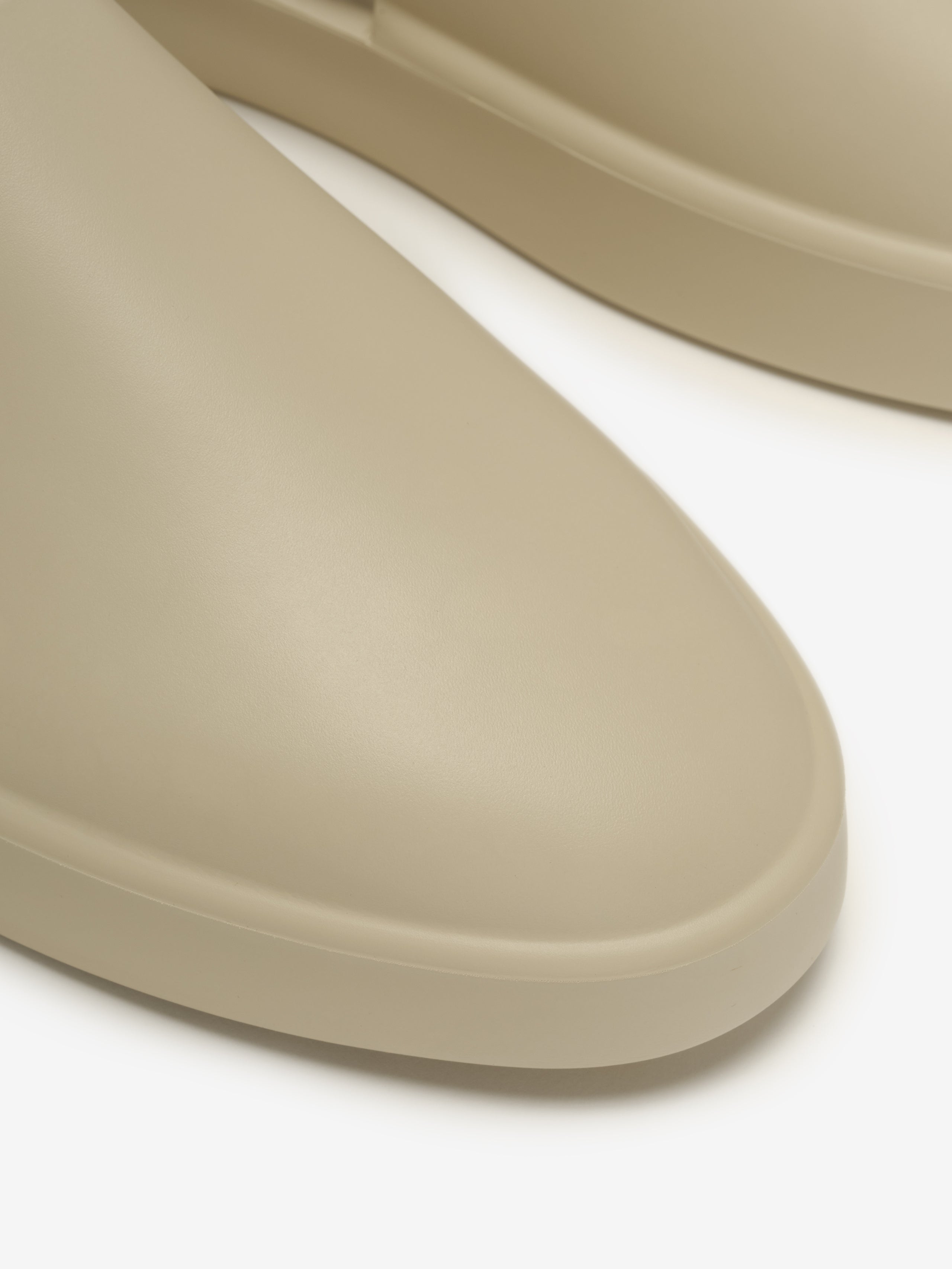 Essentials California 1.0 slip-on footwear in a soft beige tone, featuring a smooth, rounded toe and clean minimalist profile for versatile modern casual wear.