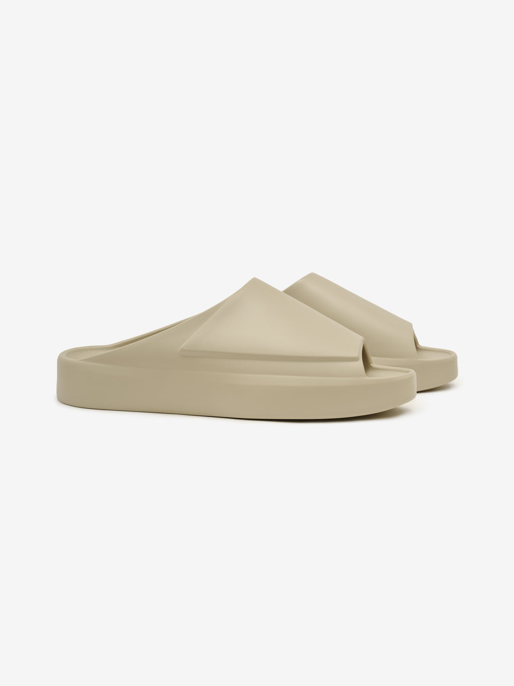 Essentials Los Feliz slip-on footwear in a smooth beige color featuring a thick cushioned sole and a sleek, angular upper design for contemporary casual comfort.