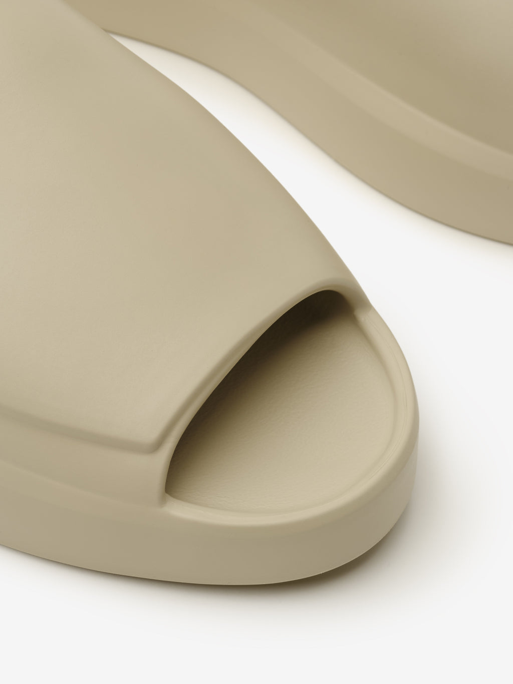 Essentials Los Feliz slip-on footwear in a soft beige tone with a smooth, molded design featuring a rounded open toe and comfortable contoured footbed for casual wear.