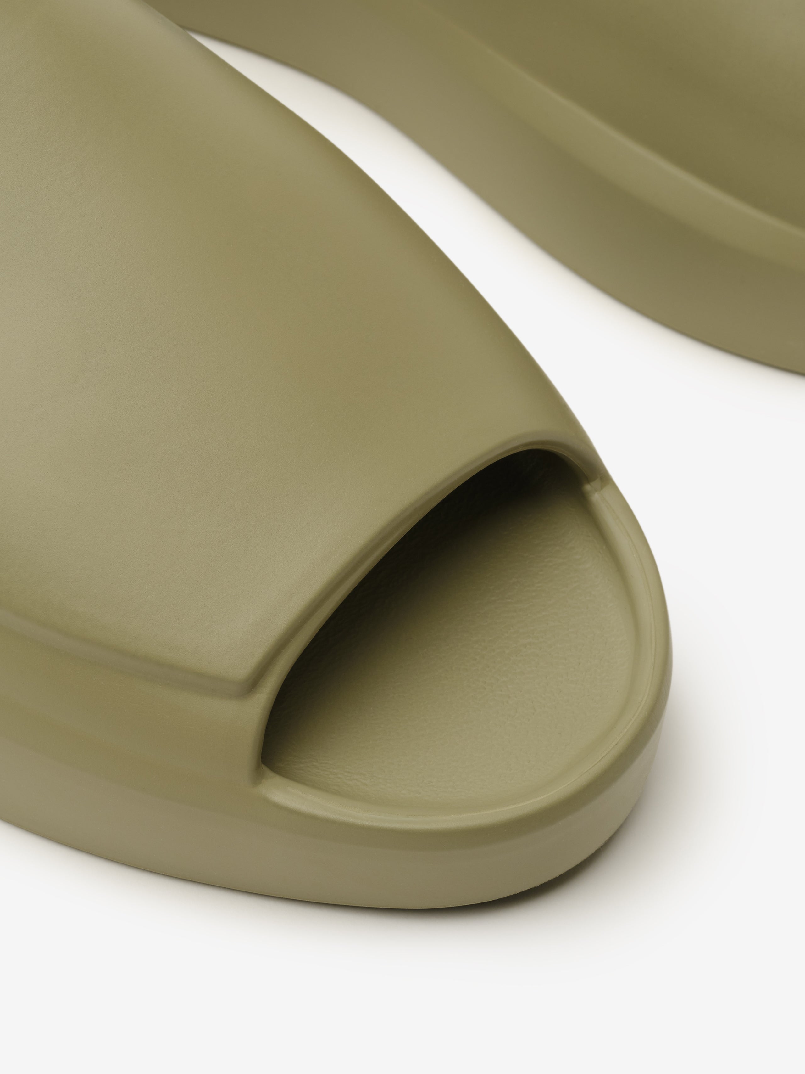 Essentials Los Feliz slip-on footwear in a muted clay tone featuring a smooth, open-toe design with a streamlined upper and a cushioned sole for understated casual comfort.