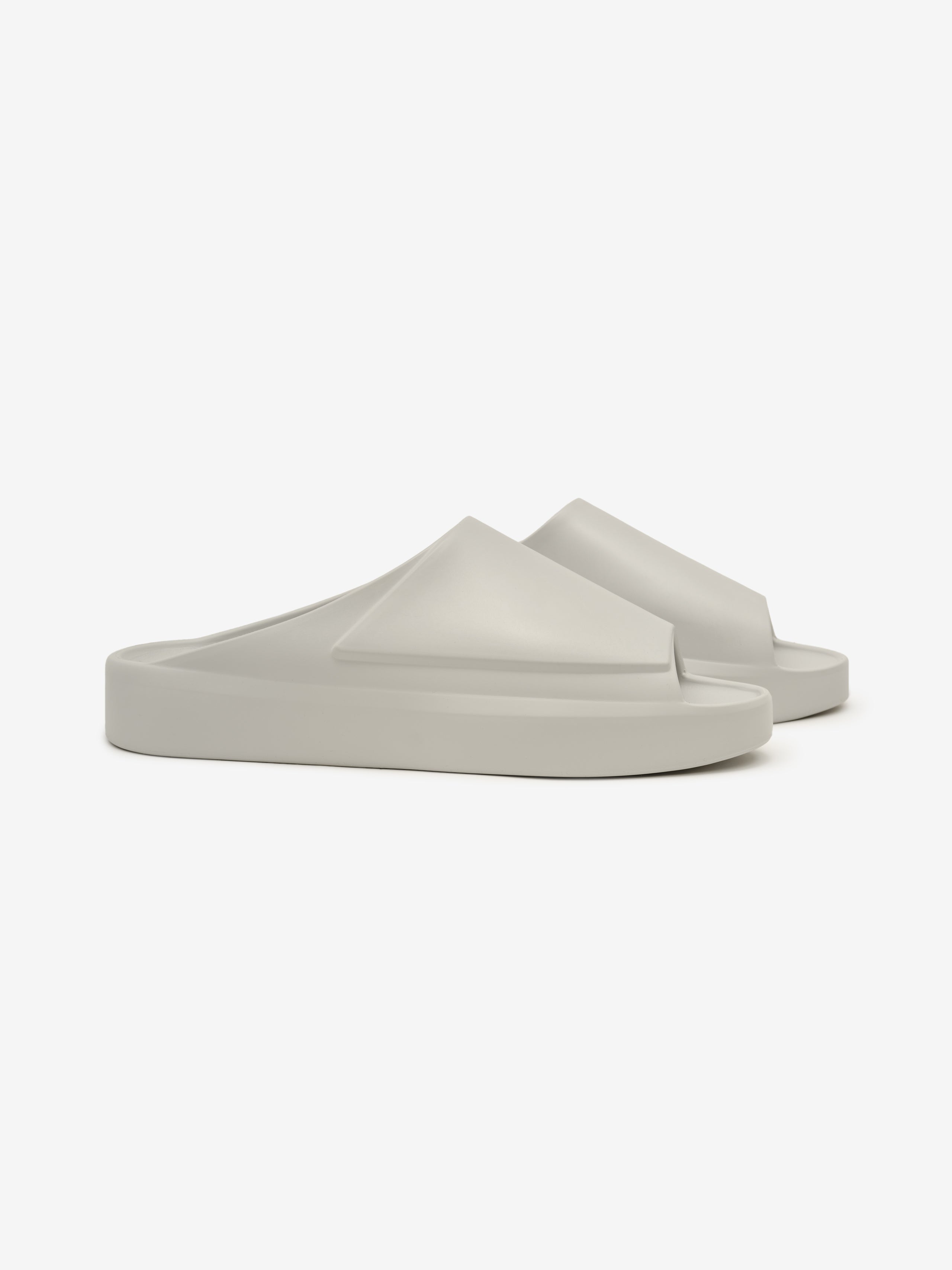 Essentials Los Feliz slip-on footwear in a soft, neutral shade with a smooth, molded design and a minimalist, sculpted silhouette for modern casual comfort.