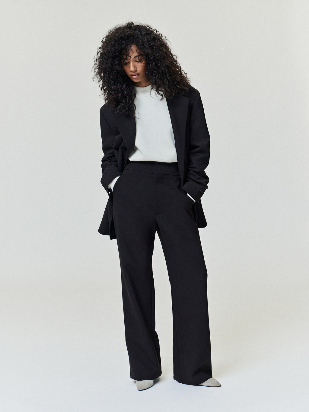 Double Weave Wool Flared Flat Front Pants worn in black with a high waist angled pockets and wide flared legs as Bottoms