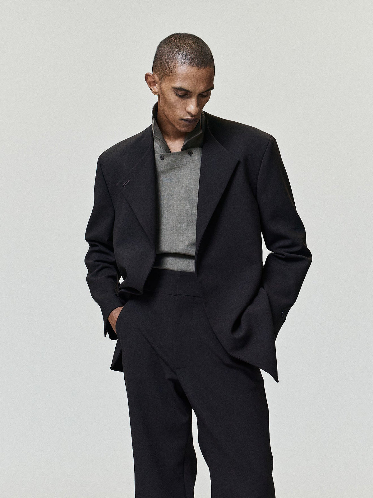 Double Weave Wool Flared Flat Front Pants worn in black with a high waist clean front and subtly flared legs styled with a tailored jacket as Bottoms