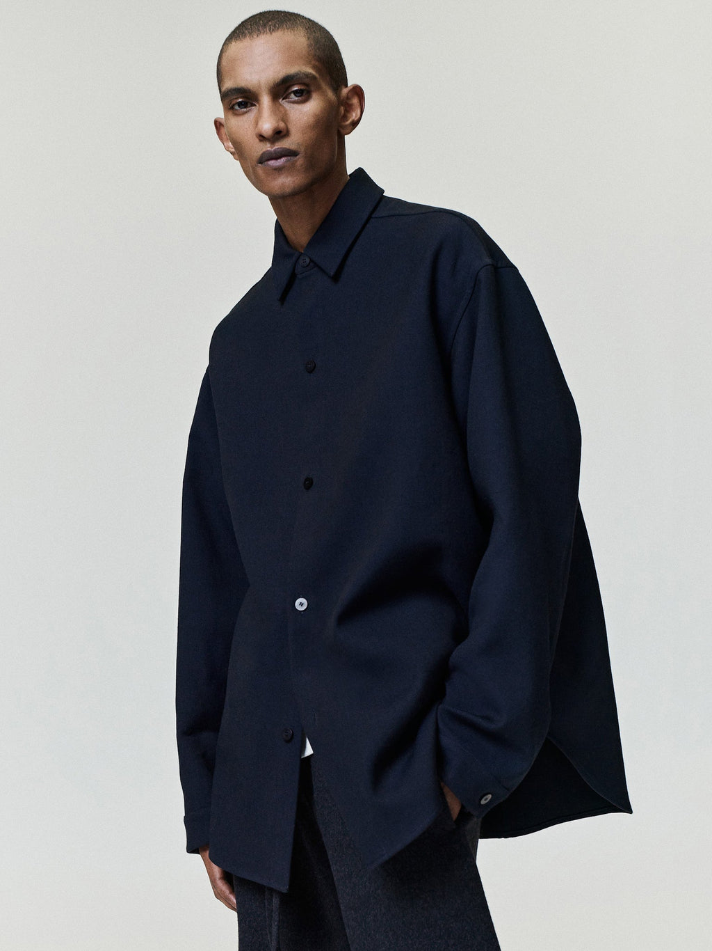 Double Weave Cotton Wool Overshirt shown worn in dark navy with a pointed collar button front relaxed fit and extended hem as Tops