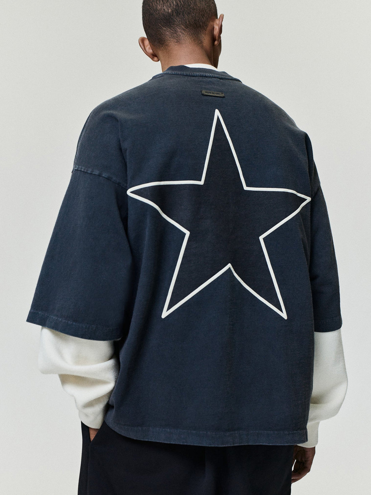 Reflection Eternal Tee in dark navy shown from the back with a large cream outlined star graphic and layered white sleeves as Tops