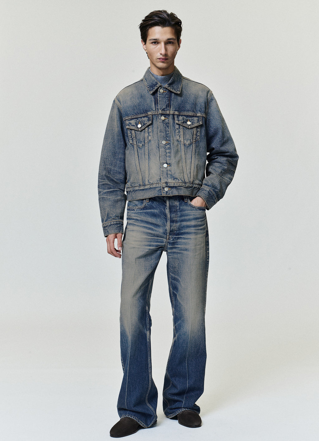 Flared Jeans in faded blue denim styled on a model with a five pocket design and relaxed flared legs as Bottoms