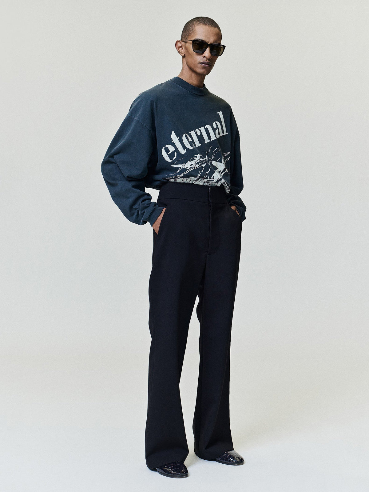 Flight Long Sleeve Tee in dark navy with cream Eternal lettering and aircraft artwork styled with black trousers on a model as Tops