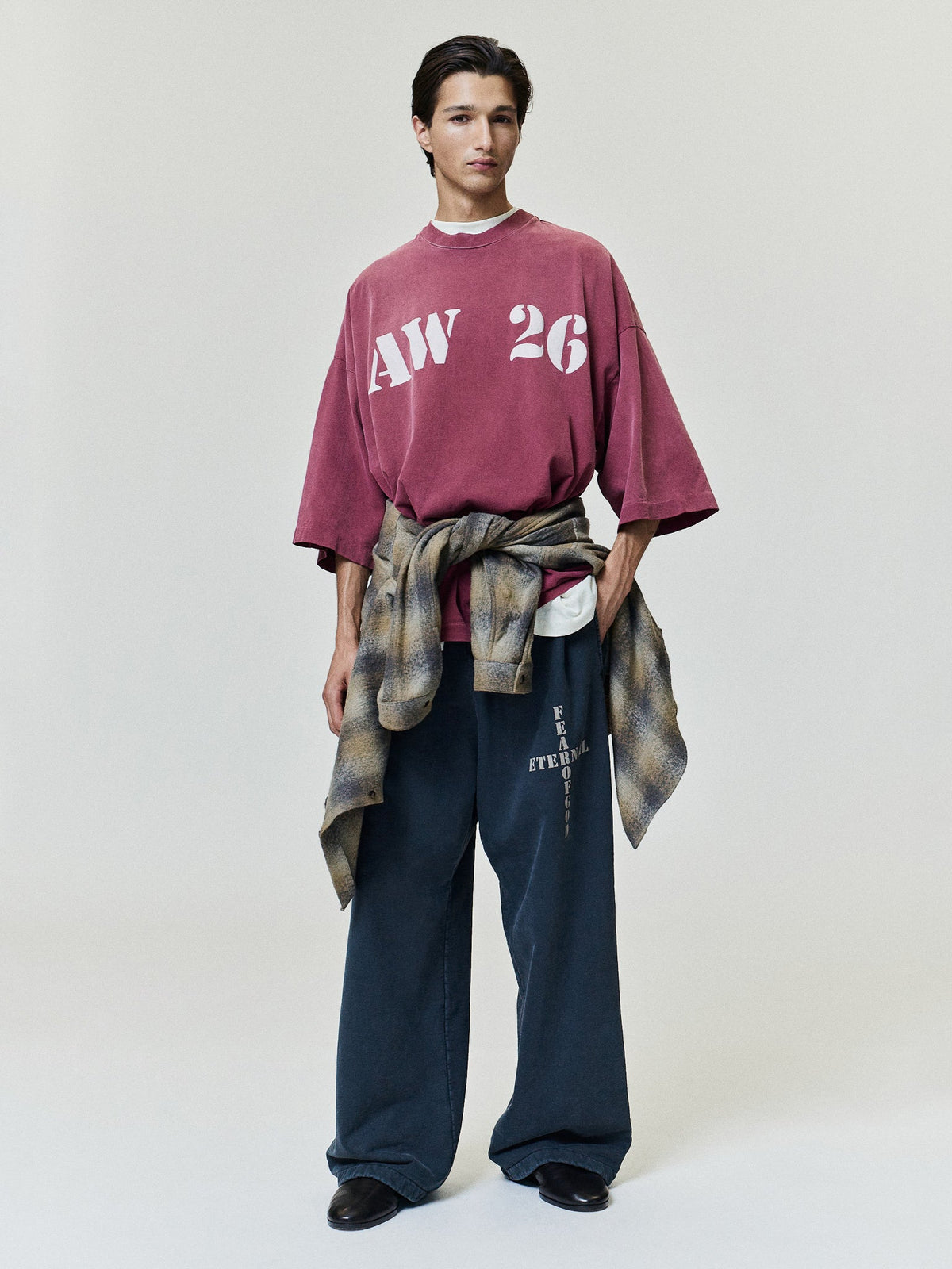Cross Wide Leg Sweatpants in dark navy with relaxed wide legs and vertical Fear of God Eternal branding worn by a model as Bottoms