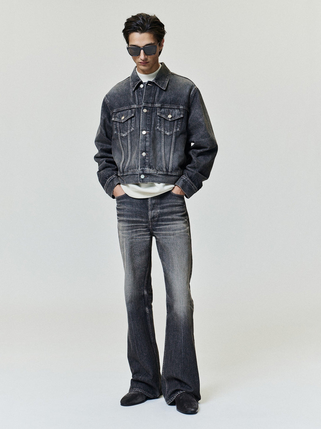 Denim Trucker Jacket in dark washed denim styled on a model with pointed collar button front flap chest pockets long sleeves and button cuffs as Outerwear