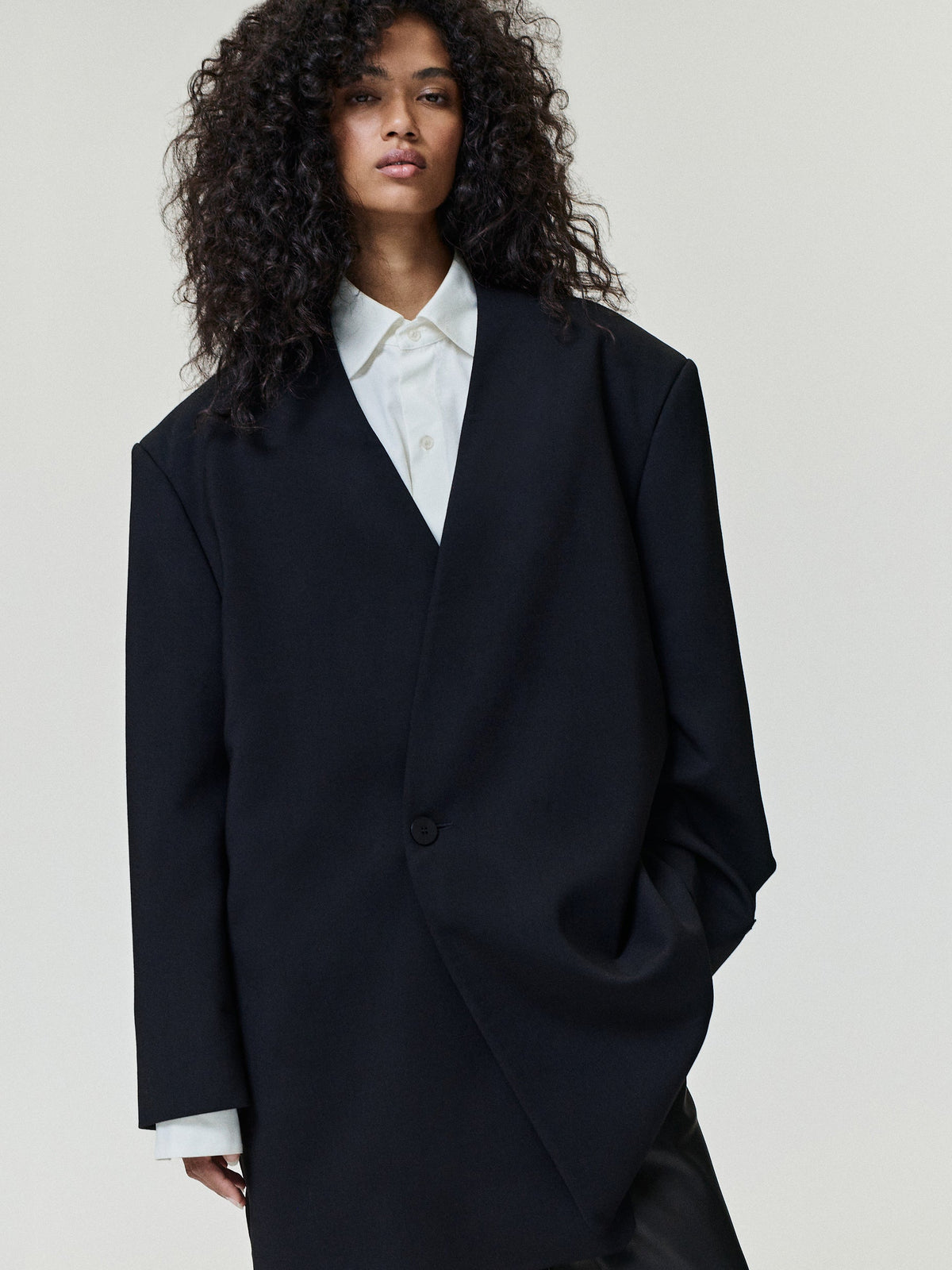 Easy Care Wool Lapelless Mid-length Jacket in dark navy worn over a white shirt with a clean collar one button closure and relaxed mid-length silhouette as Outerwear