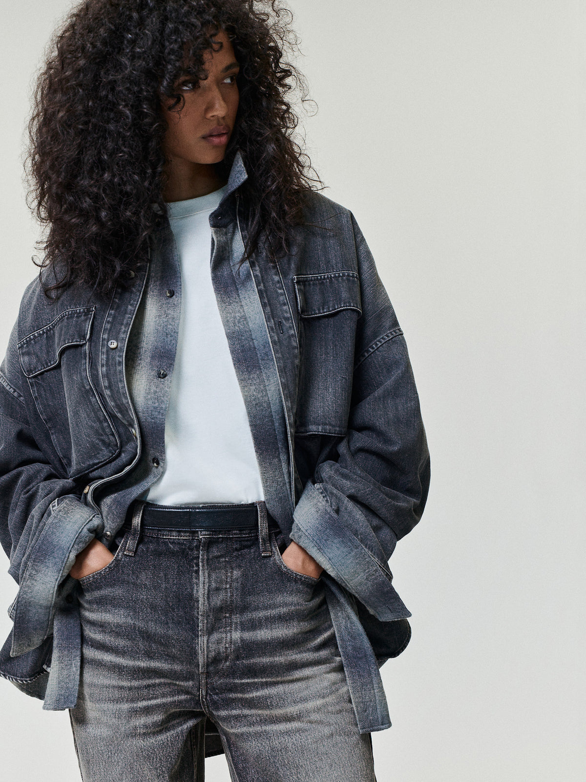 Denim Military Shirt in dark gray denim styled on a model with flap chest pockets rolled sleeves and a button front as Tops