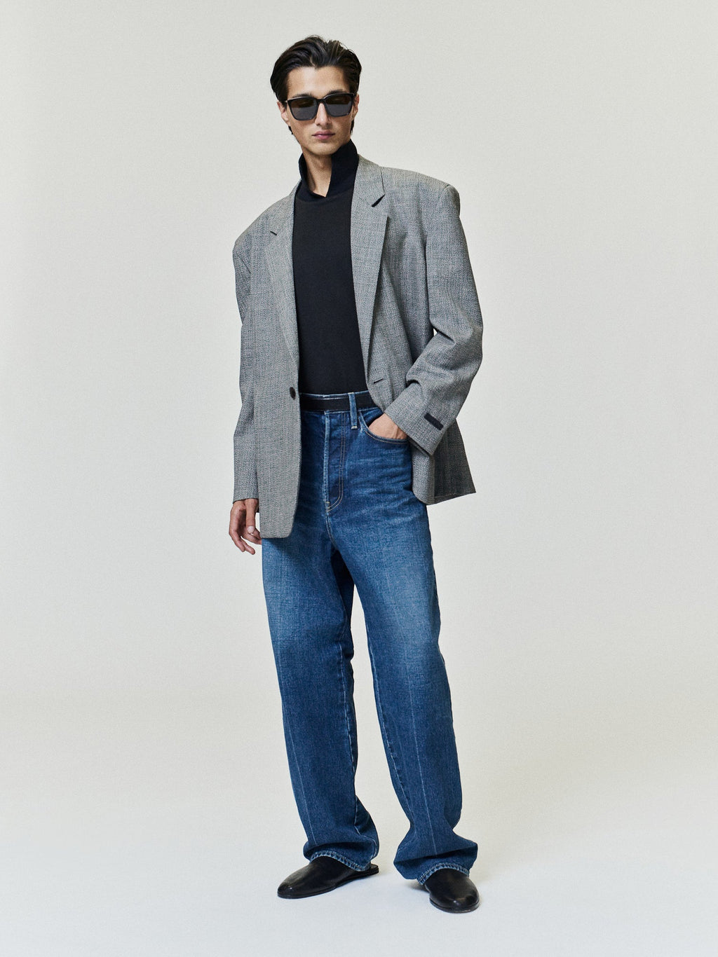 Relaxed Fit Jeans in blue shown on a model with a relaxed leg silhouette styled with a gray blazer black top and black shoes as Bottoms