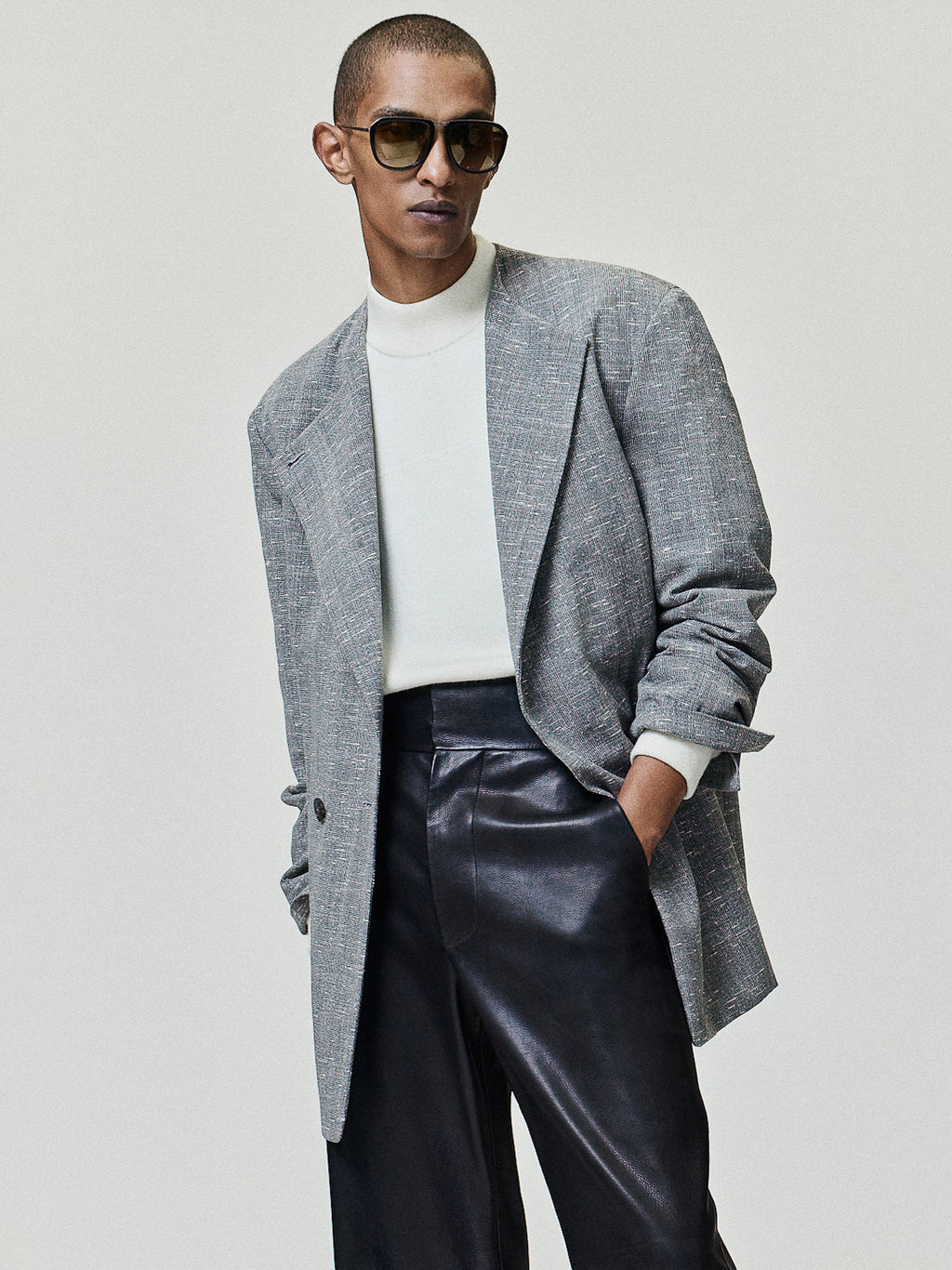 Slub Wool Cotton Belted Jacket worn in gray with a relaxed belted silhouette layered over a white mock neck and styled with black leather trousers as Outerwear