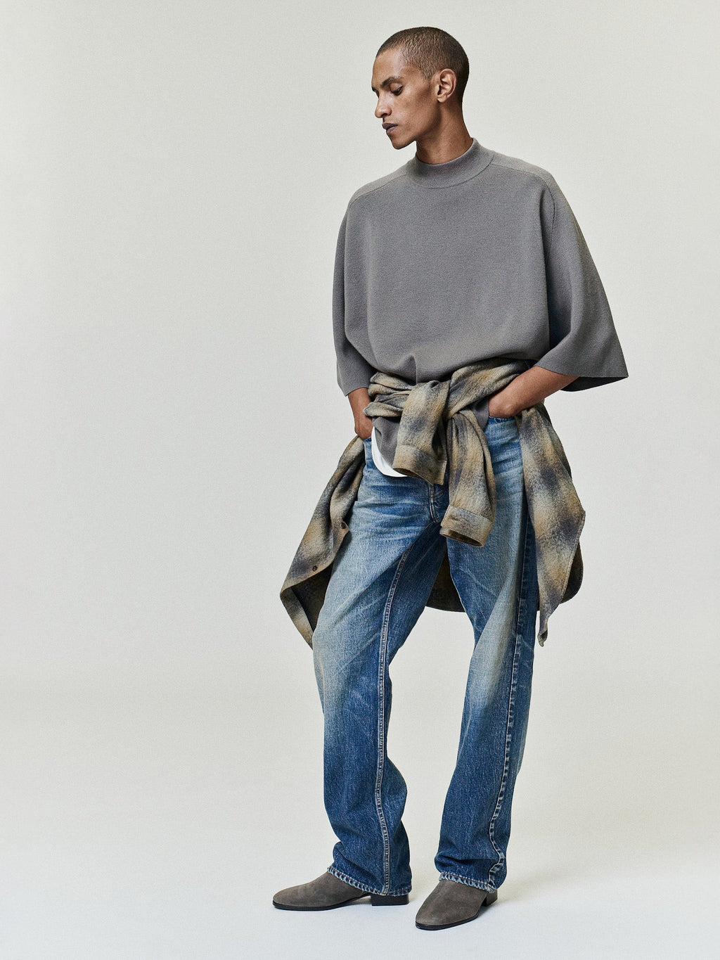 Straight Fit Jeans in blue shown on a model with a relaxed straight leg silhouette and worn finish paired with a gray top and shirt tied at the waist as Bottoms