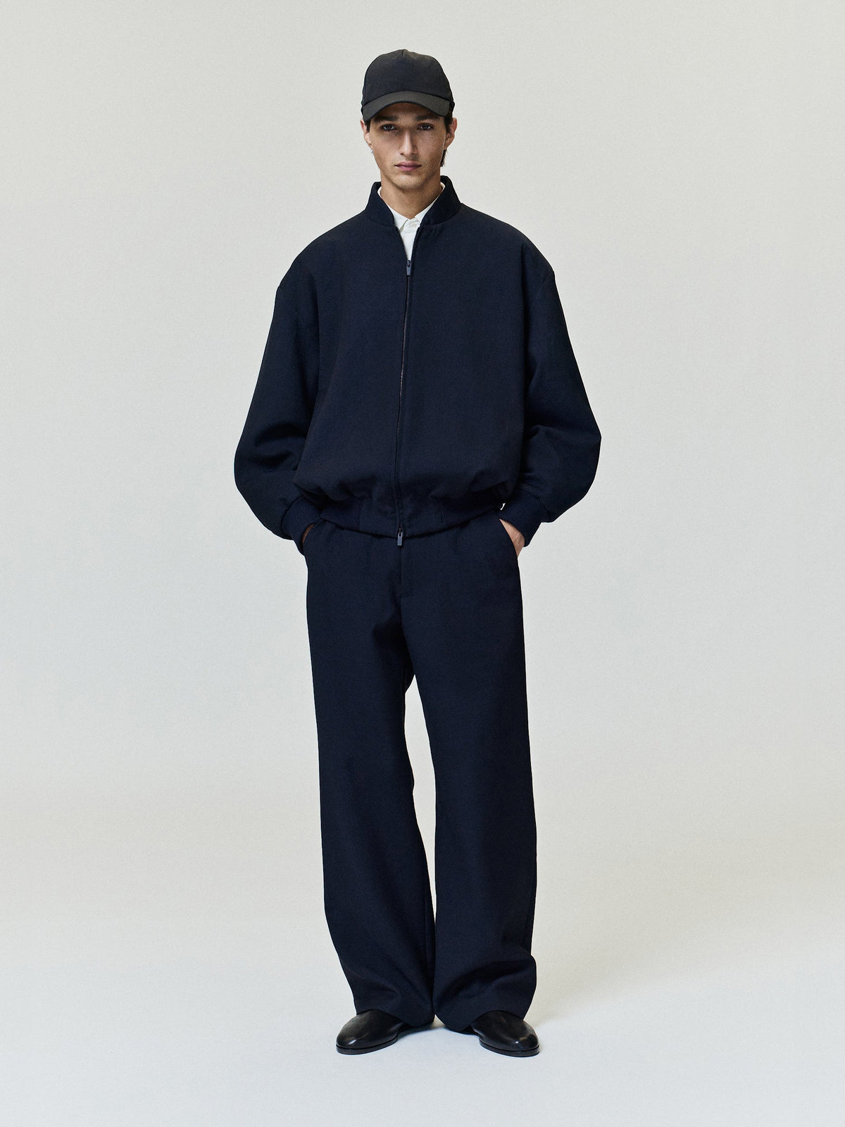Double Weave Cotton Wool Eternal Bomber shown worn in dark navy with a zip front high collar relaxed fit and ribbed cuffs as Outerwear