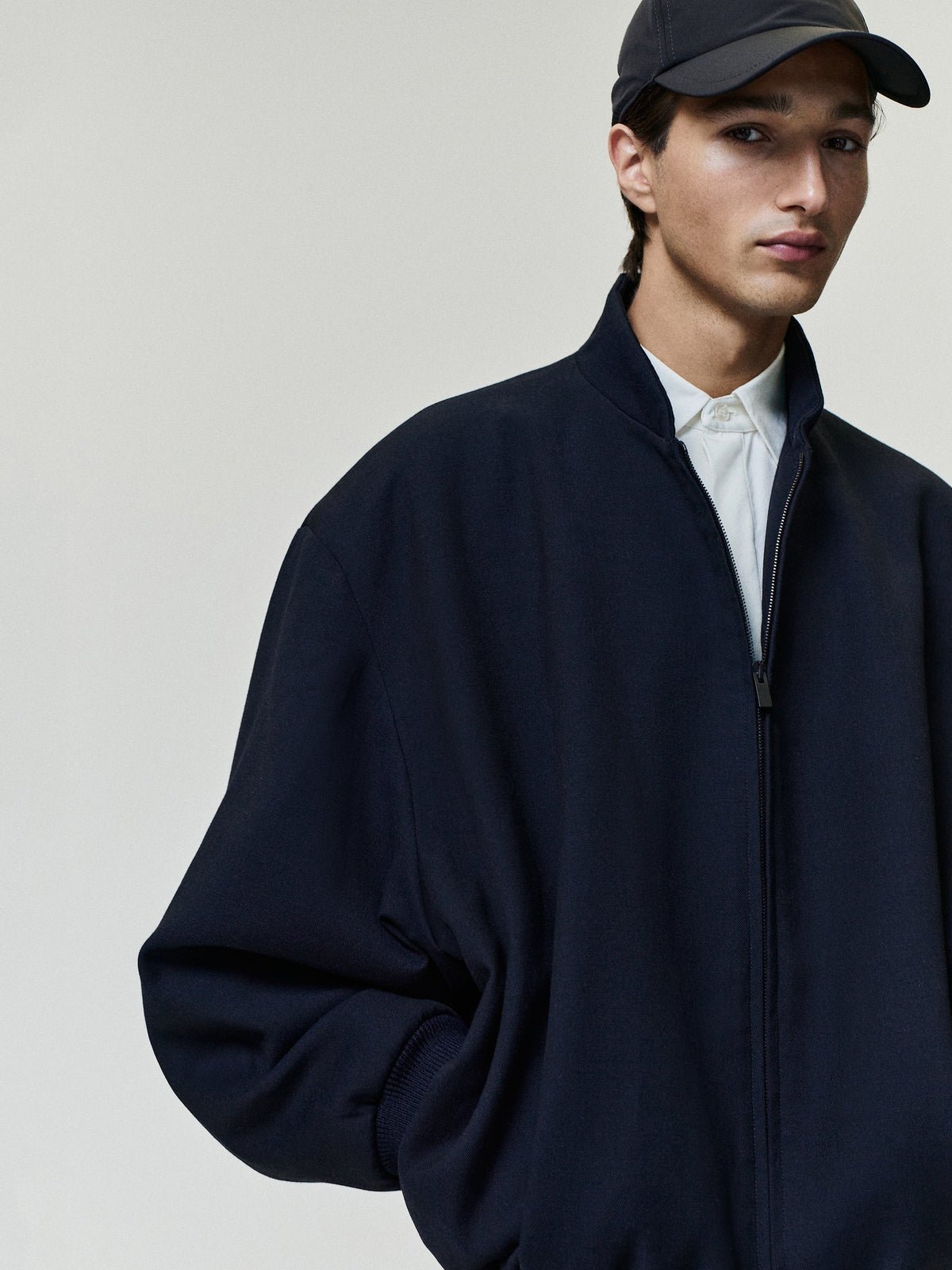 Double Weave Cotton Wool Eternal Bomber worn in dark navy with a full zip front stand collar relaxed fit and ribbed cuffs as Outerwear