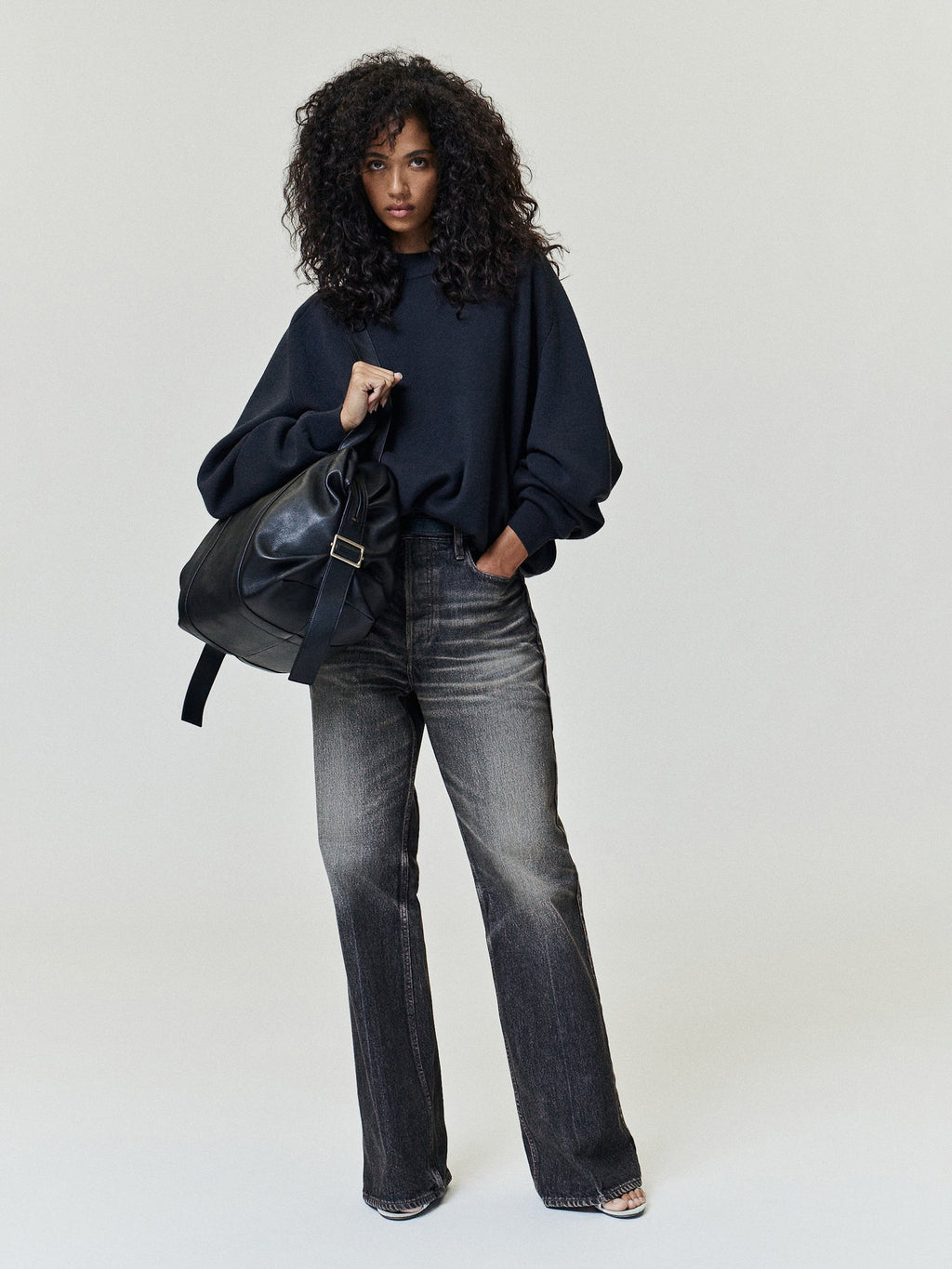 Flared Jeans in washed charcoal denim styled on a model with a high rise waist subtle whiskering and wide flared legs as Bottoms