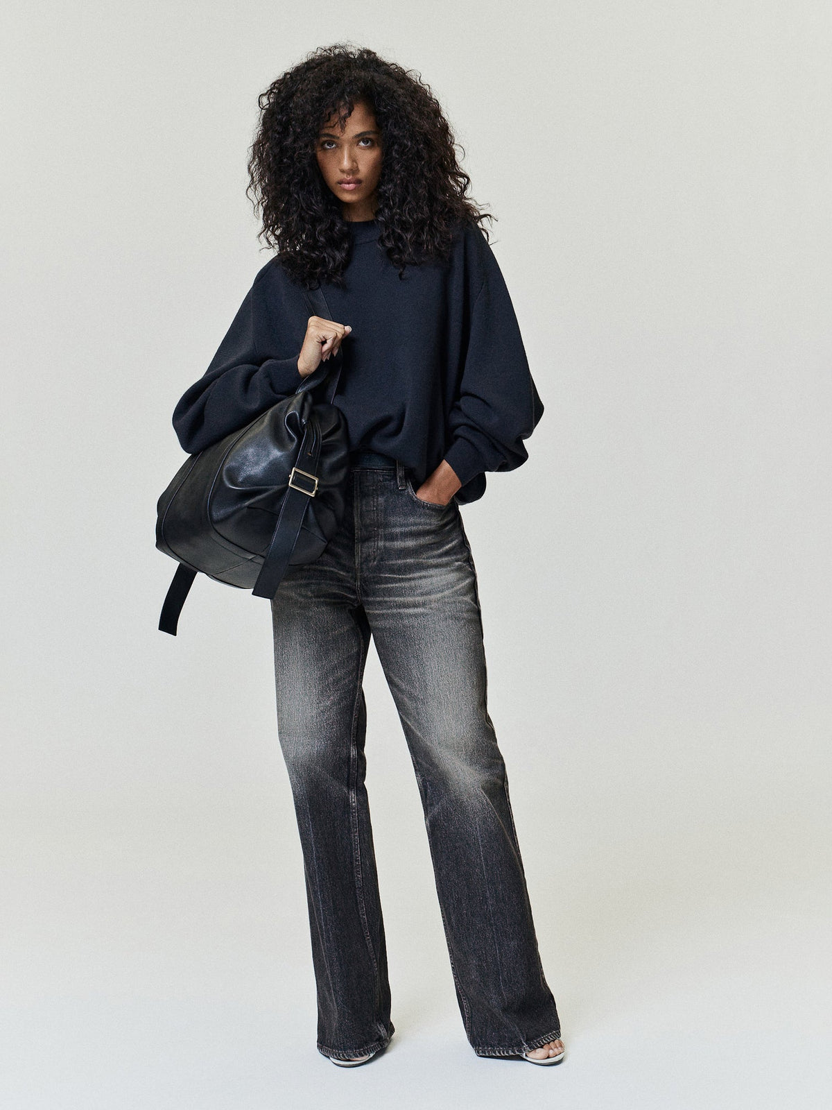 Flared Jeans in washed charcoal denim styled on a model with a high rise waist subtle whiskering and wide flared legs as Bottoms