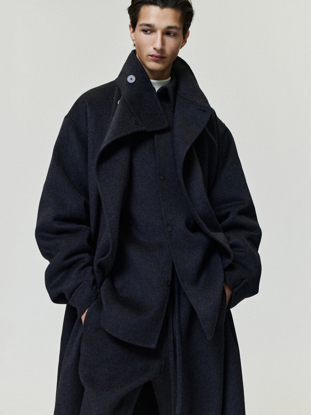 Double Face Wool Cashmere Overcoat in charcoal worn by a model with wide lapels high collar layered front and relaxed silhouette as Outerwear