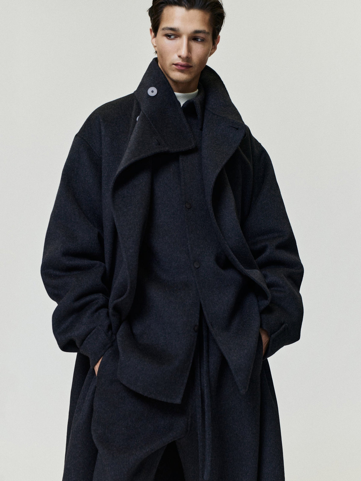 Double Face Wool Cashmere Overcoat in charcoal worn by a model with wide lapels high collar layered front and relaxed silhouette as Outerwear