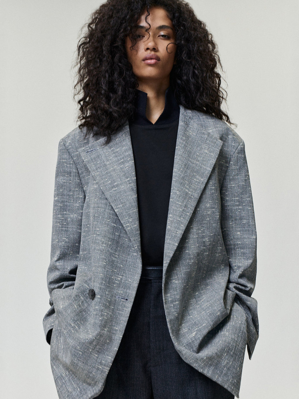 Slub Wool Cotton Belted Jacket worn in textured gray with an oversized tailored silhouette layered over black knitwear as Outerwear