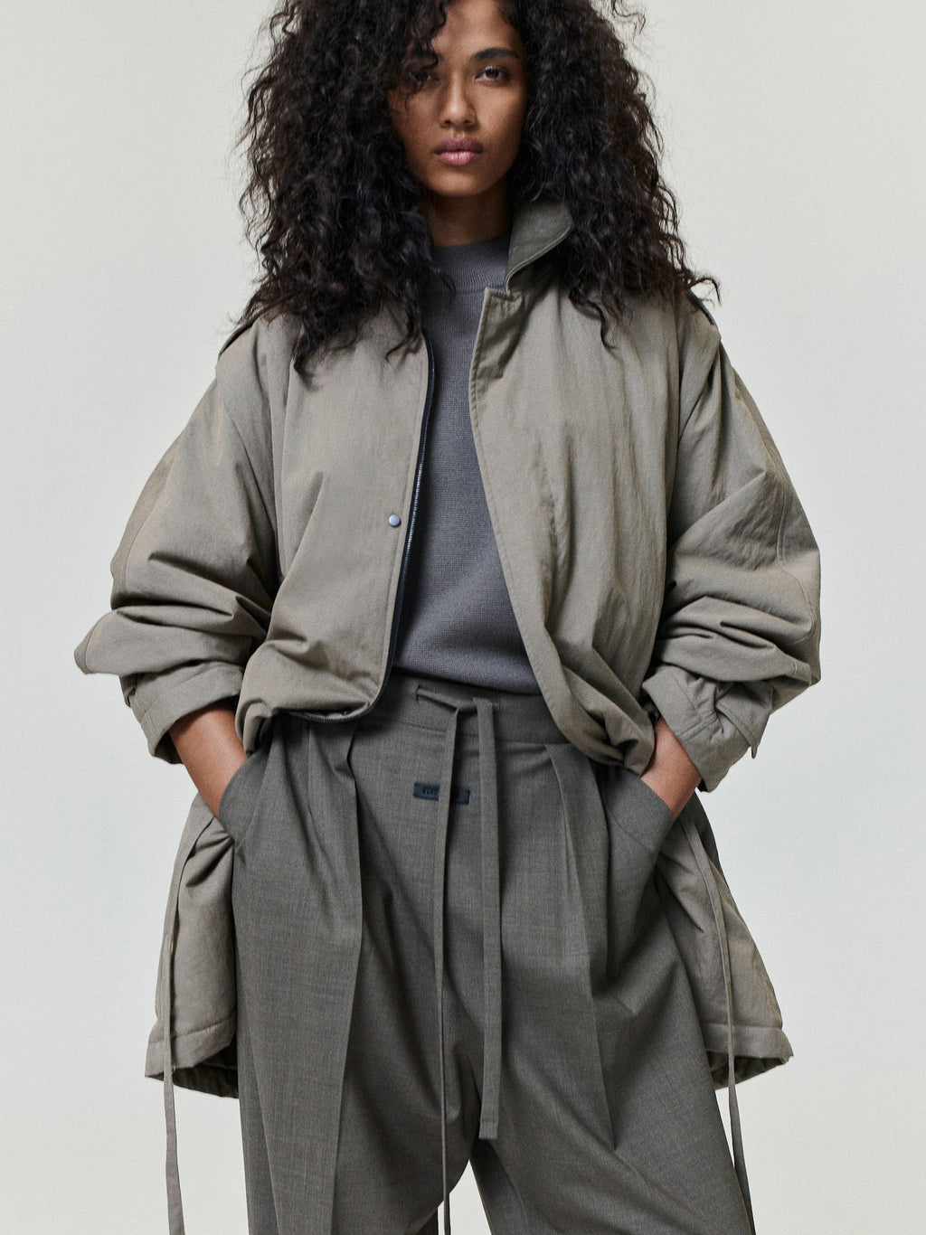 Washed Cotton Nylon Gabardine Field Jacket modeled in gray olive with a stand collar snap front gathered sleeves and relaxed fit as Outerwear