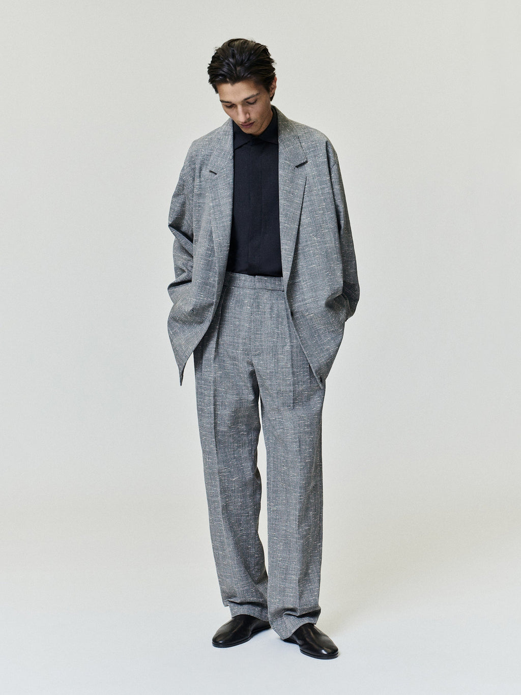 Slub Wool Box Pleat Trousers worn in textured gray with a high waist front pleats wide straight legs and relaxed tailoring styled with a matching jacket as Bottoms