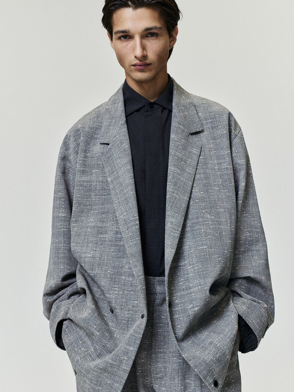 Slub Wool Cotton Relaxed Jacket worn in textured gray with notched lapels patch pockets long sleeves and an oversized fit over a dark shirt as Outerwear