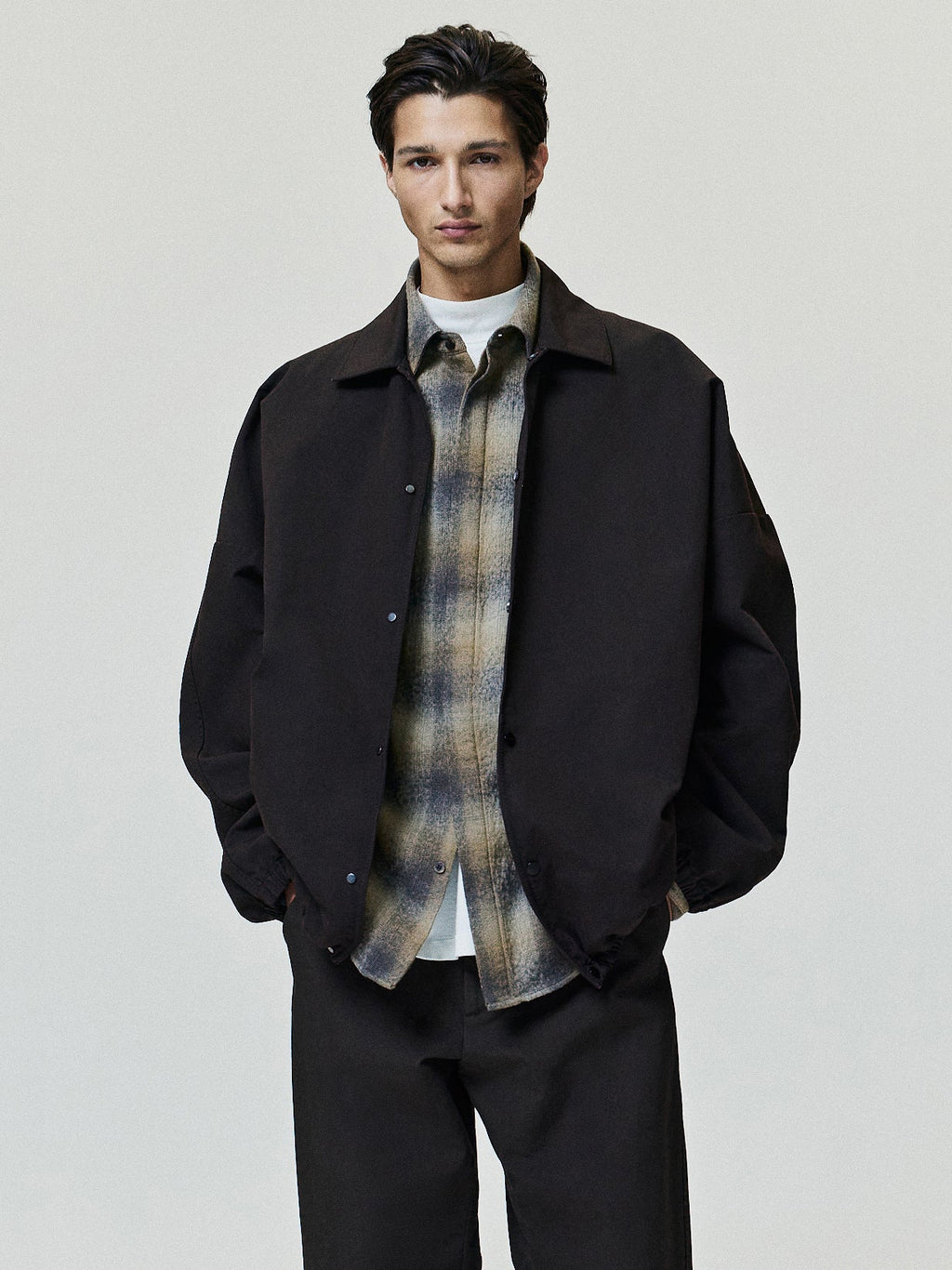 Cotton Wool Flannel Check Shirt in brown and beige plaid worn under a dark jacket showing pointed collar long sleeves button front and curved hem as Tops