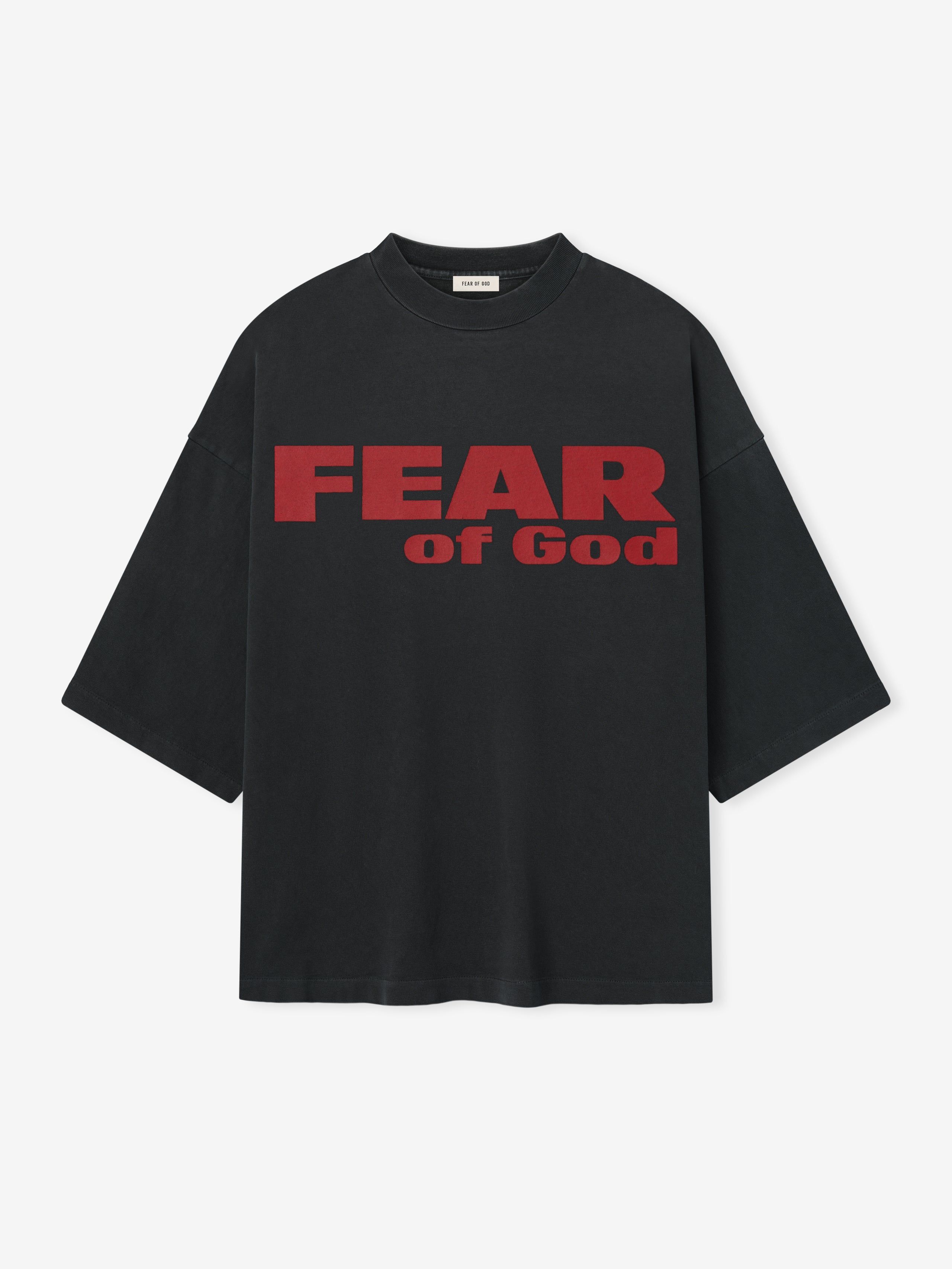 Relaxed Fear Is Gone Tee in black featuring bold red Fear of God lettering across the chest, designed with a loose fit and dropped shoulders for a modern tops style.