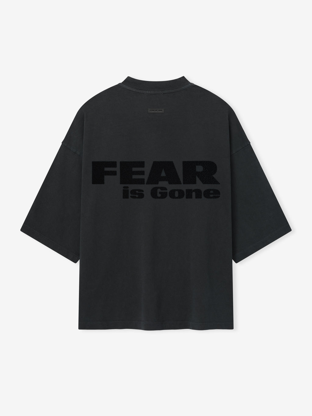 Relaxed Fear Is Gone Tee in faded black featuring large tonal Fear is Gone text across the back, designed with wide sleeves and a loose, oversized fit for casual tops style.