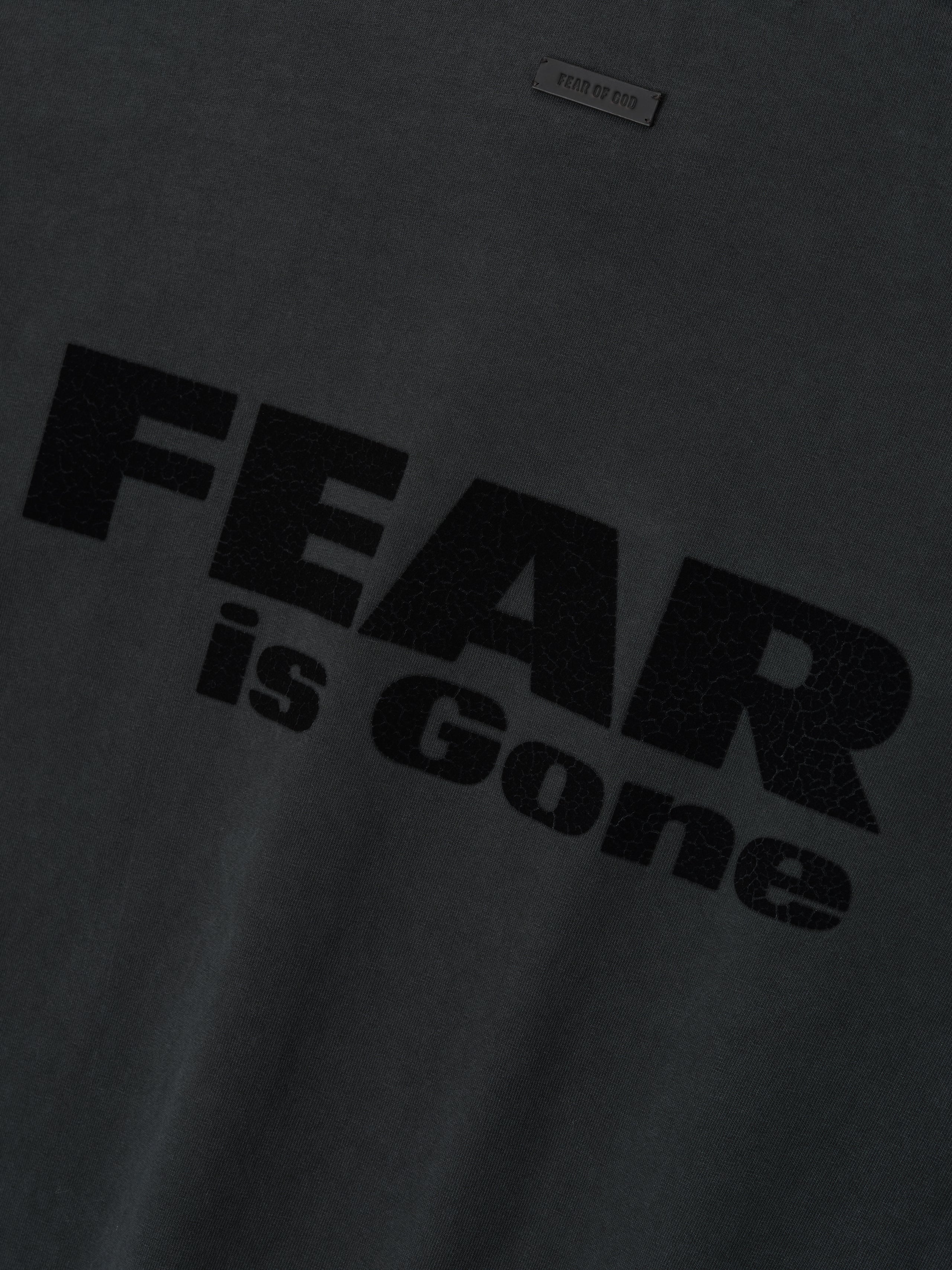 Relaxed Fear Is Gone Tee in black featuring a bold, textured Fear is Gone graphic across the chest with a subtle Fear of God patch above, crafted from soft cotton for casual tops.