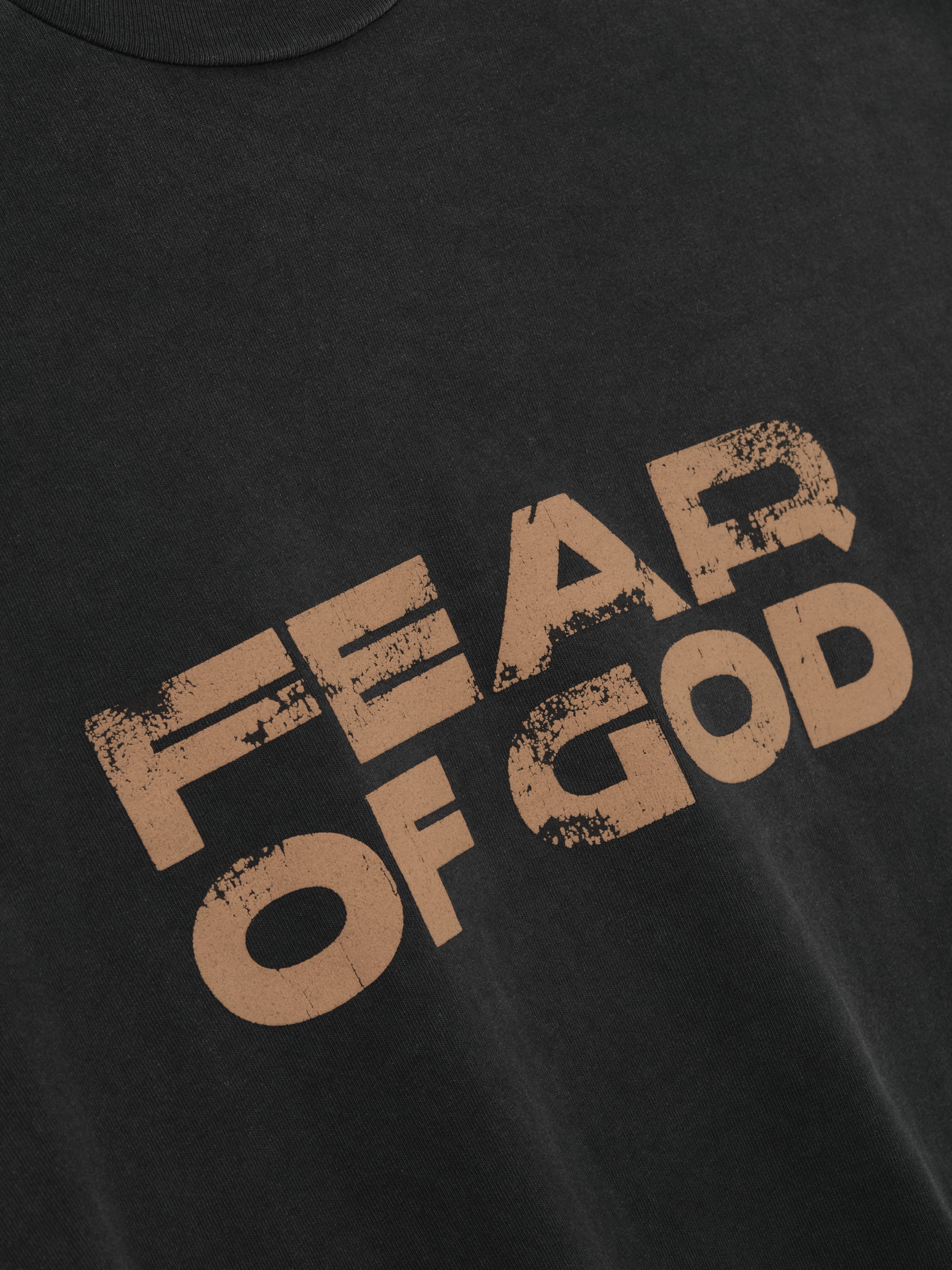 Relaxed Fear Of God Long Sleeve Tee in black with large distressed brown “FEAR OF GOD” text printed across the chest, crafted from soft cotton for casual everyday tops wear.