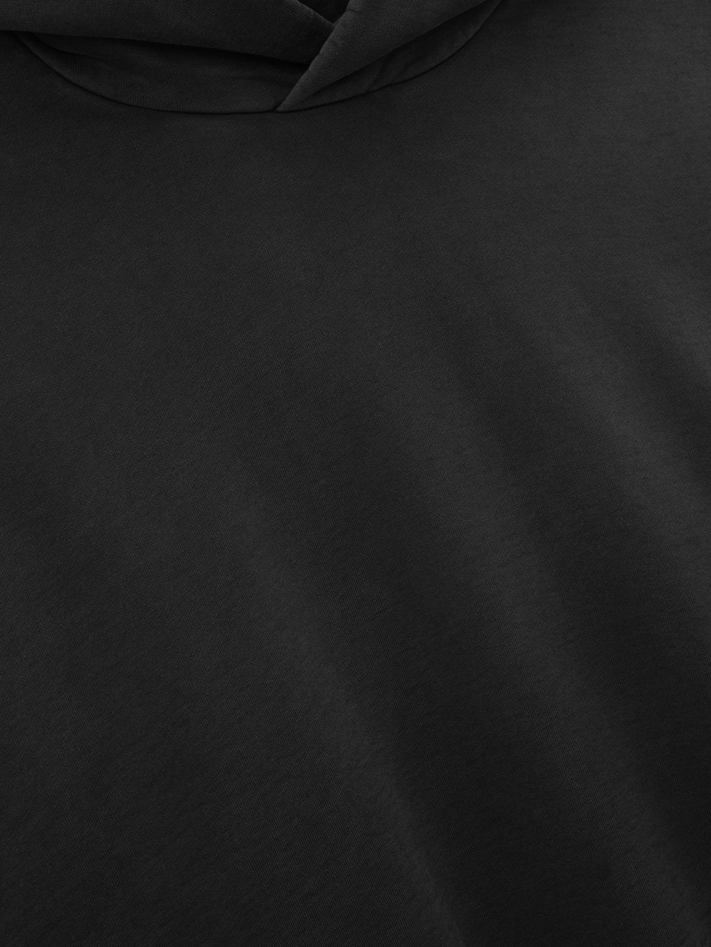 Close-up detail of the soft black fabric and hood of the Washed Hoodie, highlighting its smooth texture and subtle fading for a worn-in, casual outerwear look.