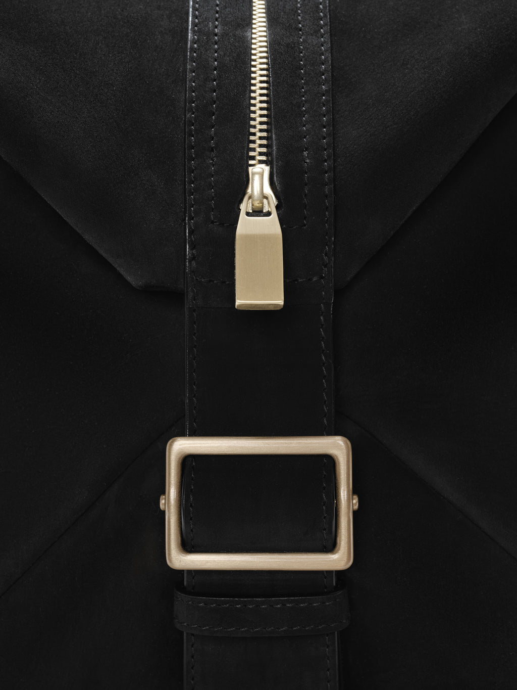 Close-up of a black Large Belted Duffle featuring a matte leather strap with neat stitching, a rectangular brushed metal buckle, and a polished gold-tone zipper pull for refined detailing.