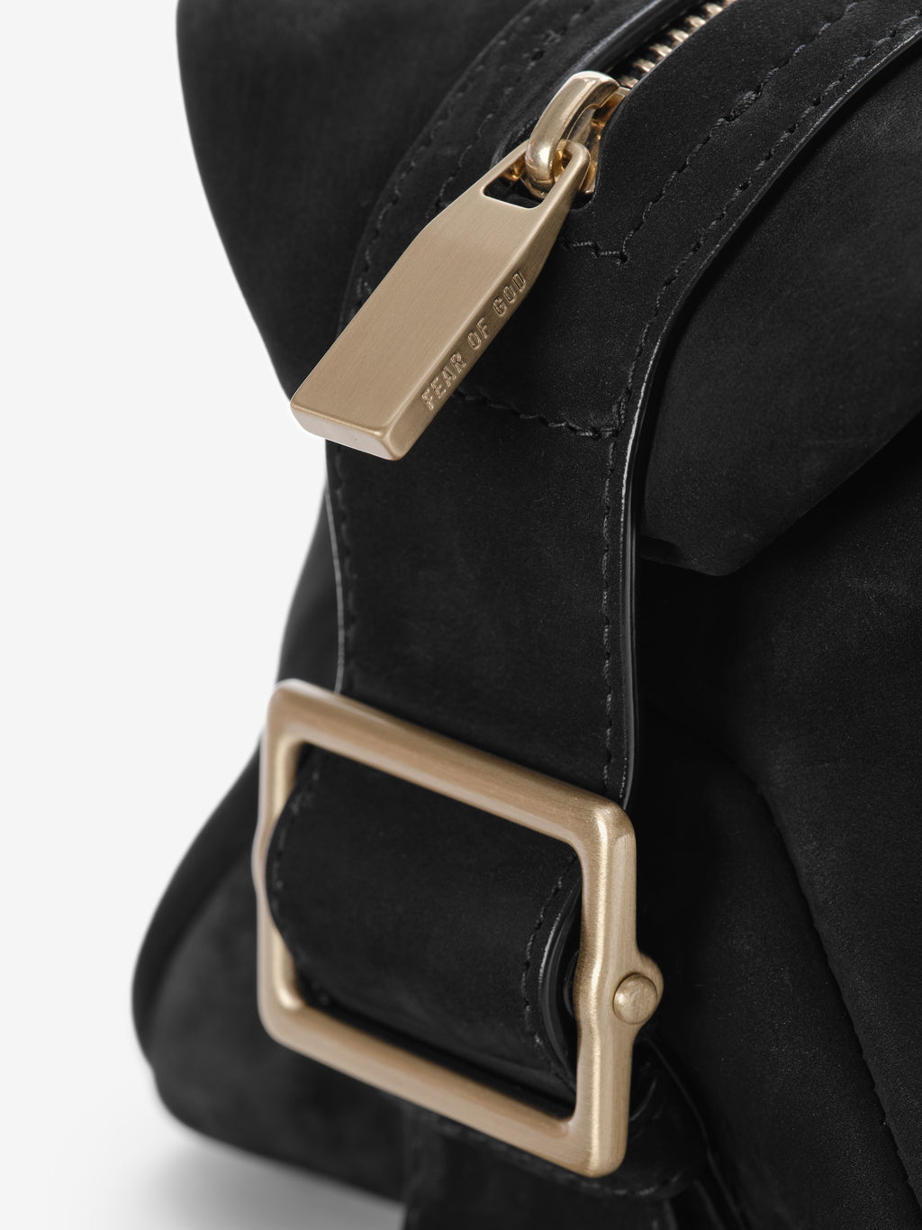 Close-up of Nubuck Leather Belted Pouch in black highlighting the smooth matte leather, a brushed gold-tone rectangular buckle, and a zipper pull engraved with subtle Fear of God branding.
