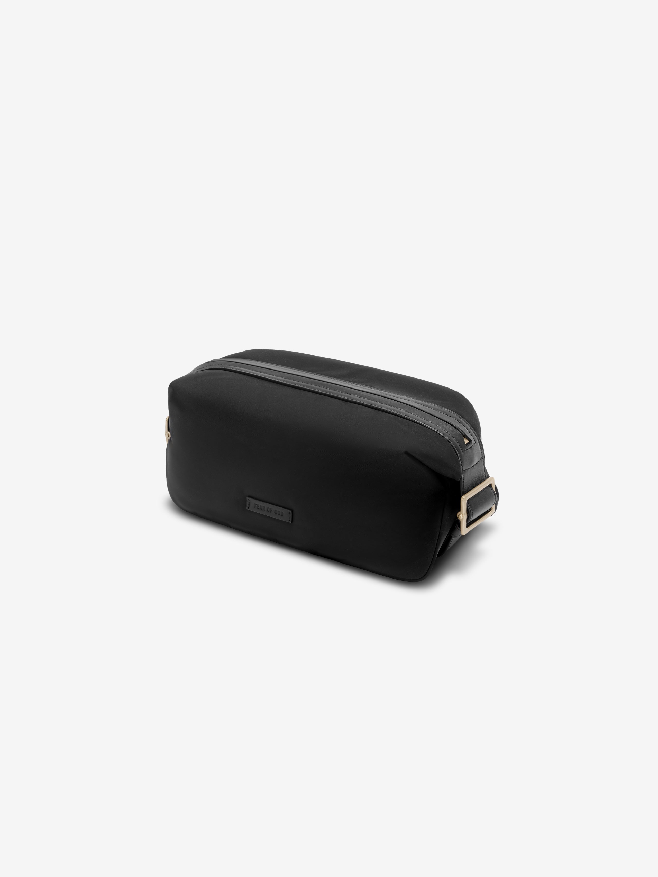 Minimalist black nylon pouch with rectangular leather buckle strap and subtle logo patch on front panel