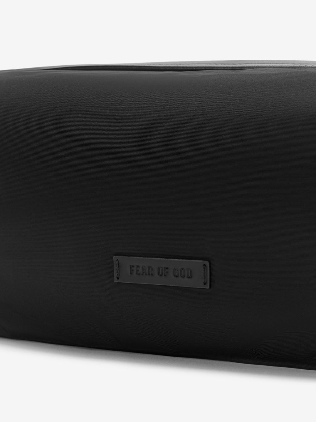 Black minimalist pouch with subtle embossed logo patch on smooth nylon fabric surface