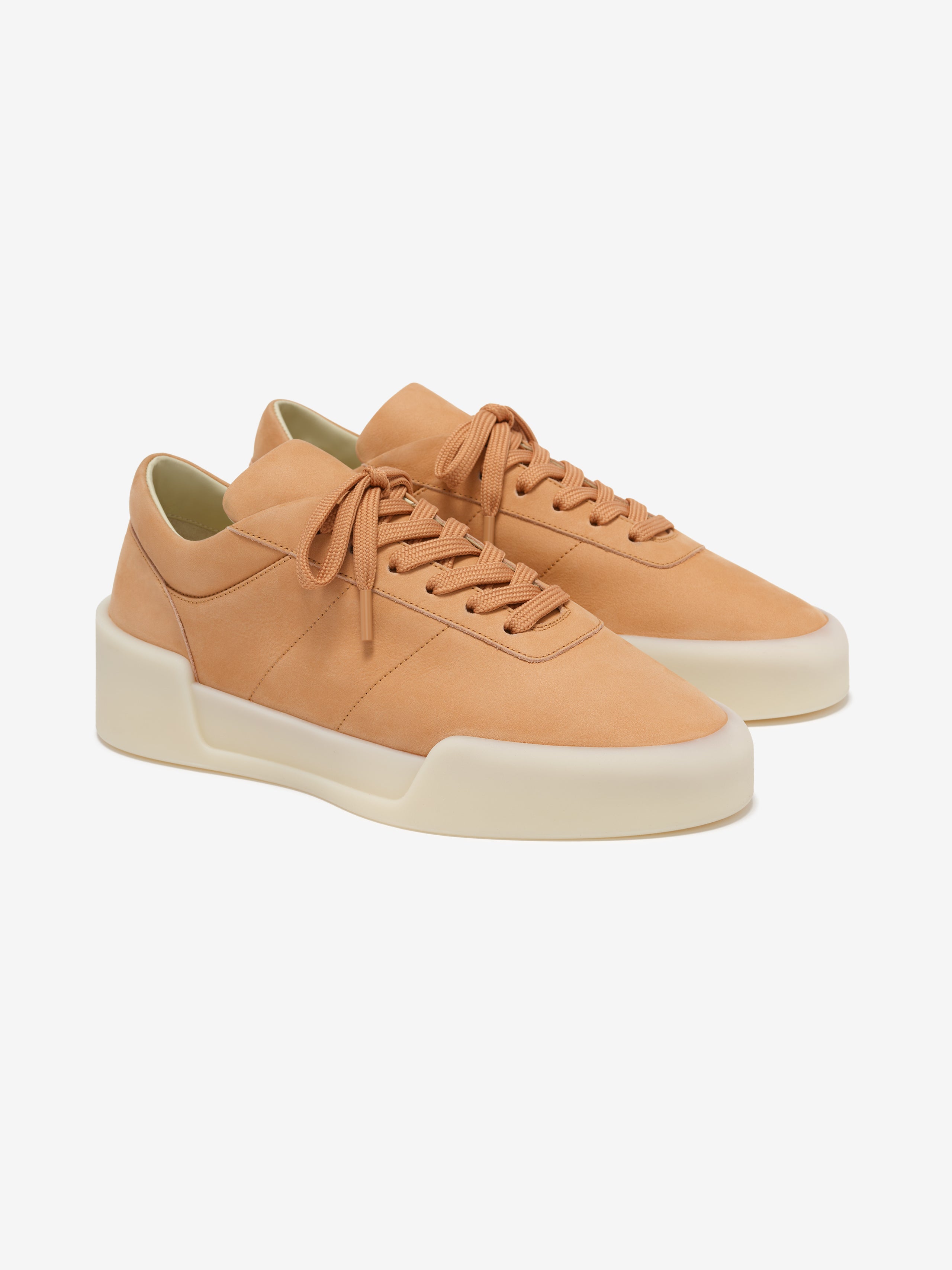 pair of tan Italian suede low-top sneakers with sculpted off-white rubber soles and tonal laces angled left