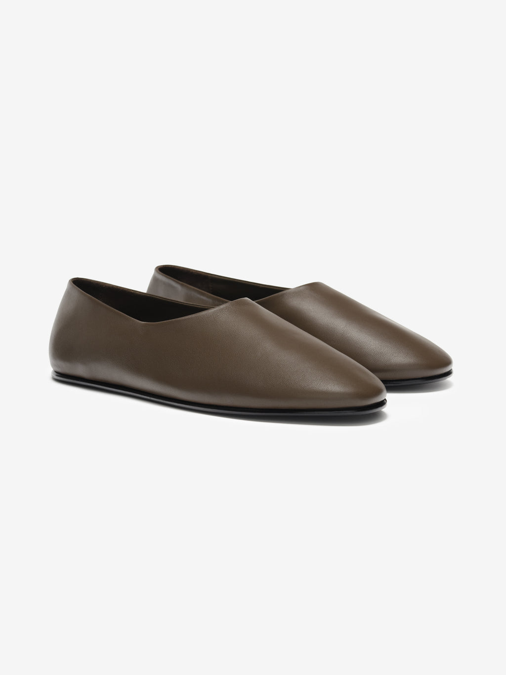 Pair of smooth brown leather slip-on flats with pointed toes and minimal stitching on light gray background