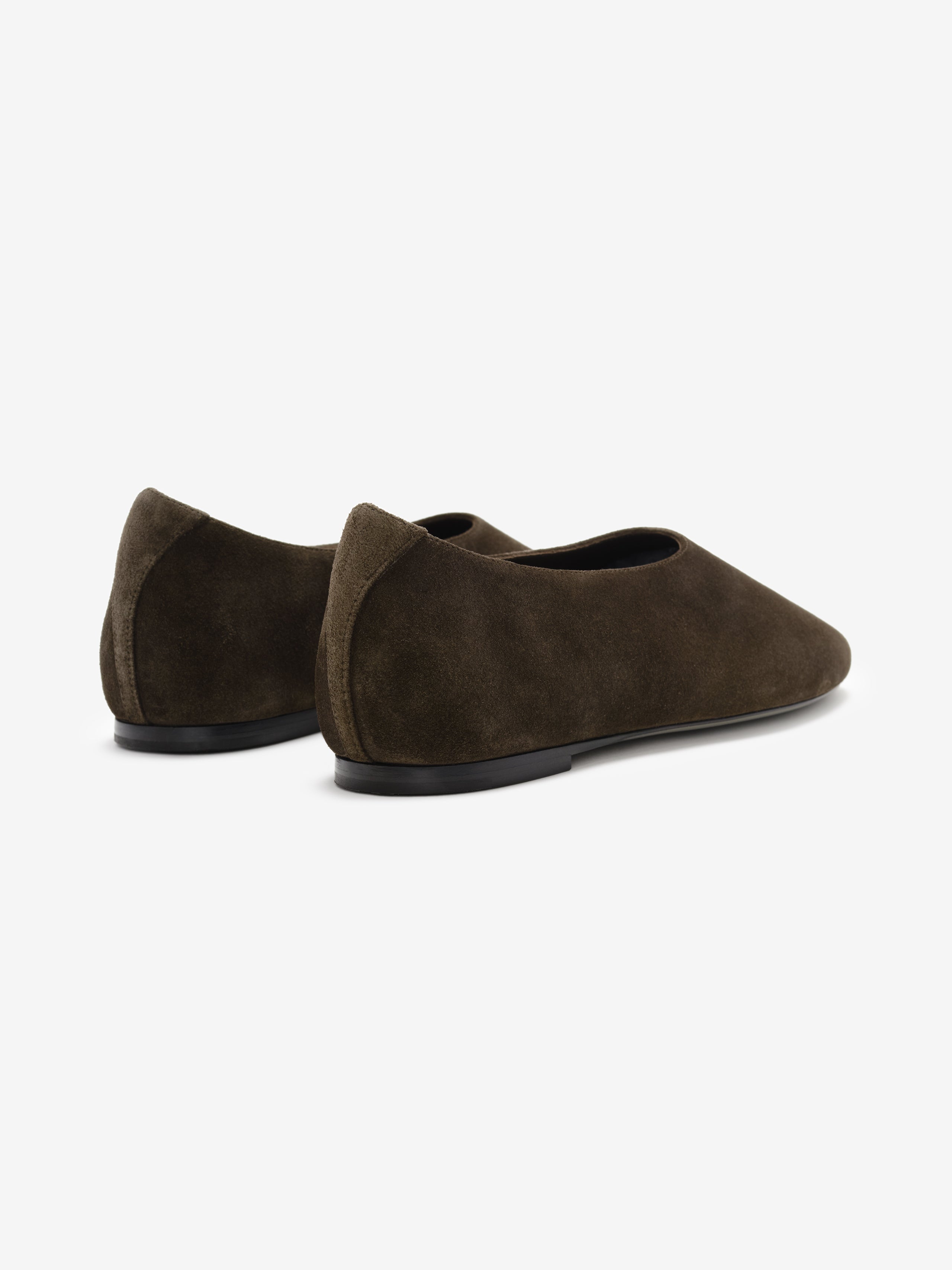 Pair of dark brown suede ballet flats with rounded toes and slim black soles on a white background