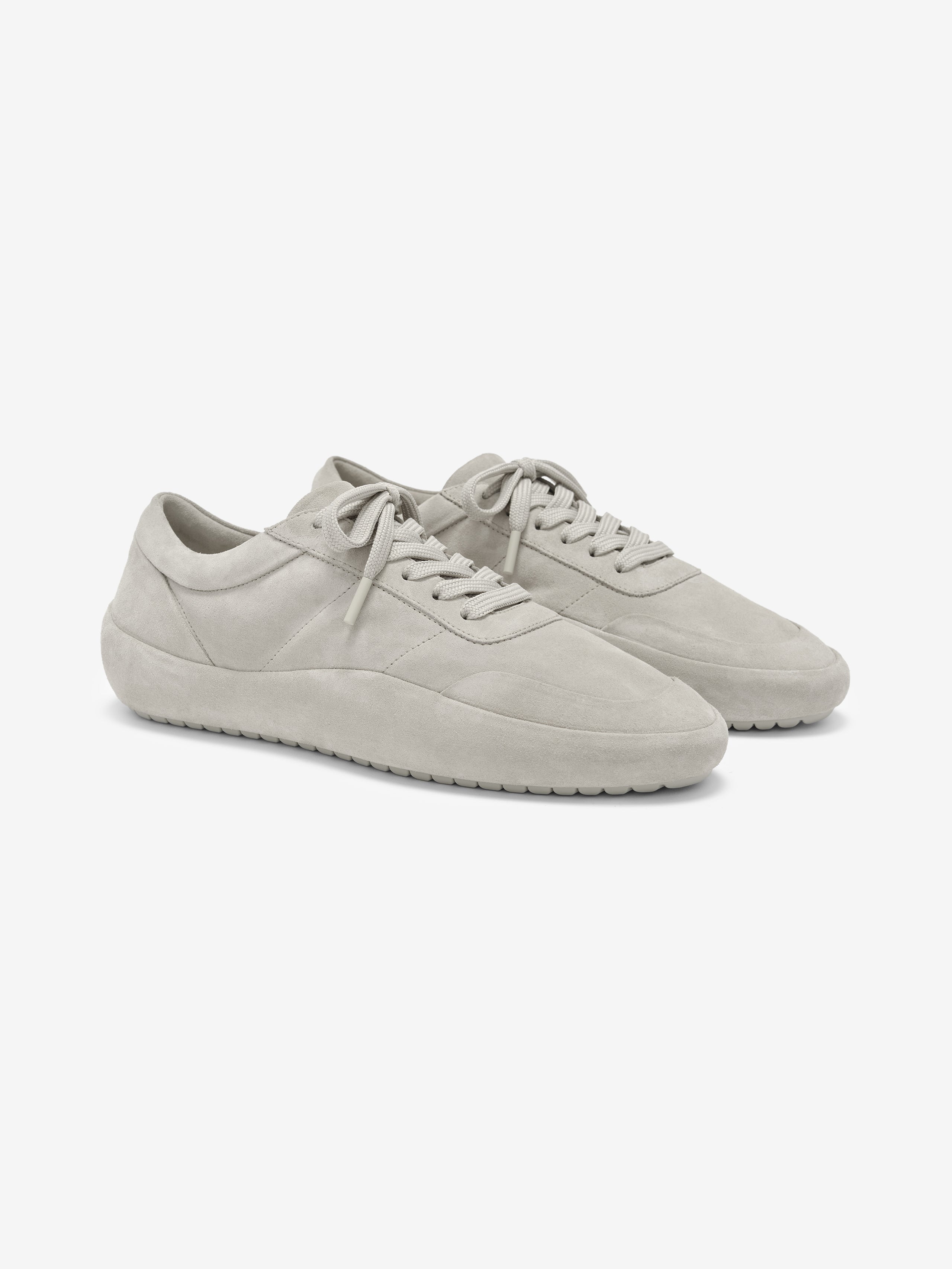 Lace Up Runner in a muted light grey suede featuring a minimalist design with tonal laces, padded collar, and a textured sole for comfortable, versatile footwear.