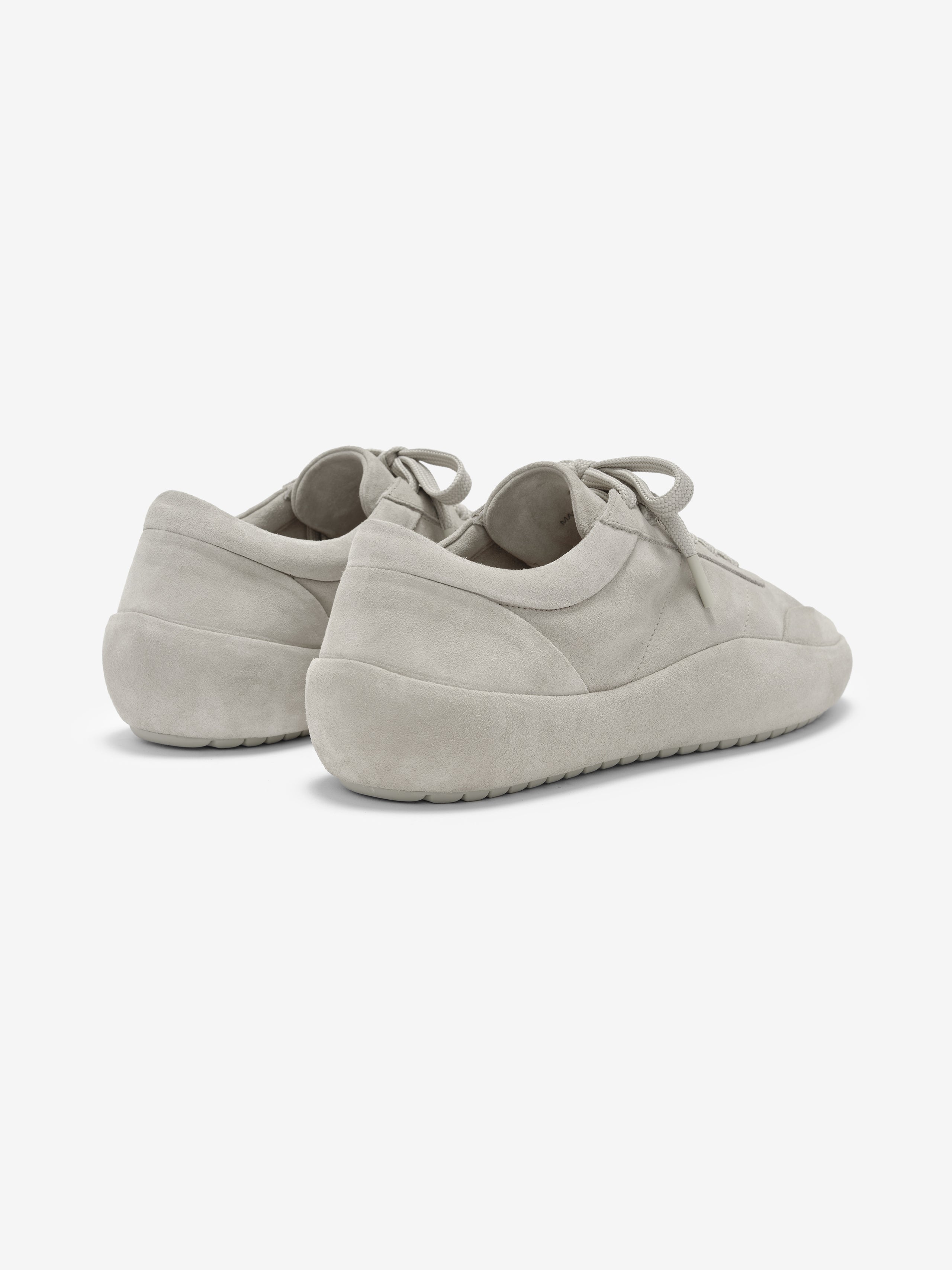 Lace Up Runner in a soft light grey suede showcasing a minimalist design with padded heels, tonal laces, and a cushioned sole for sleek, comfortable footwear.
