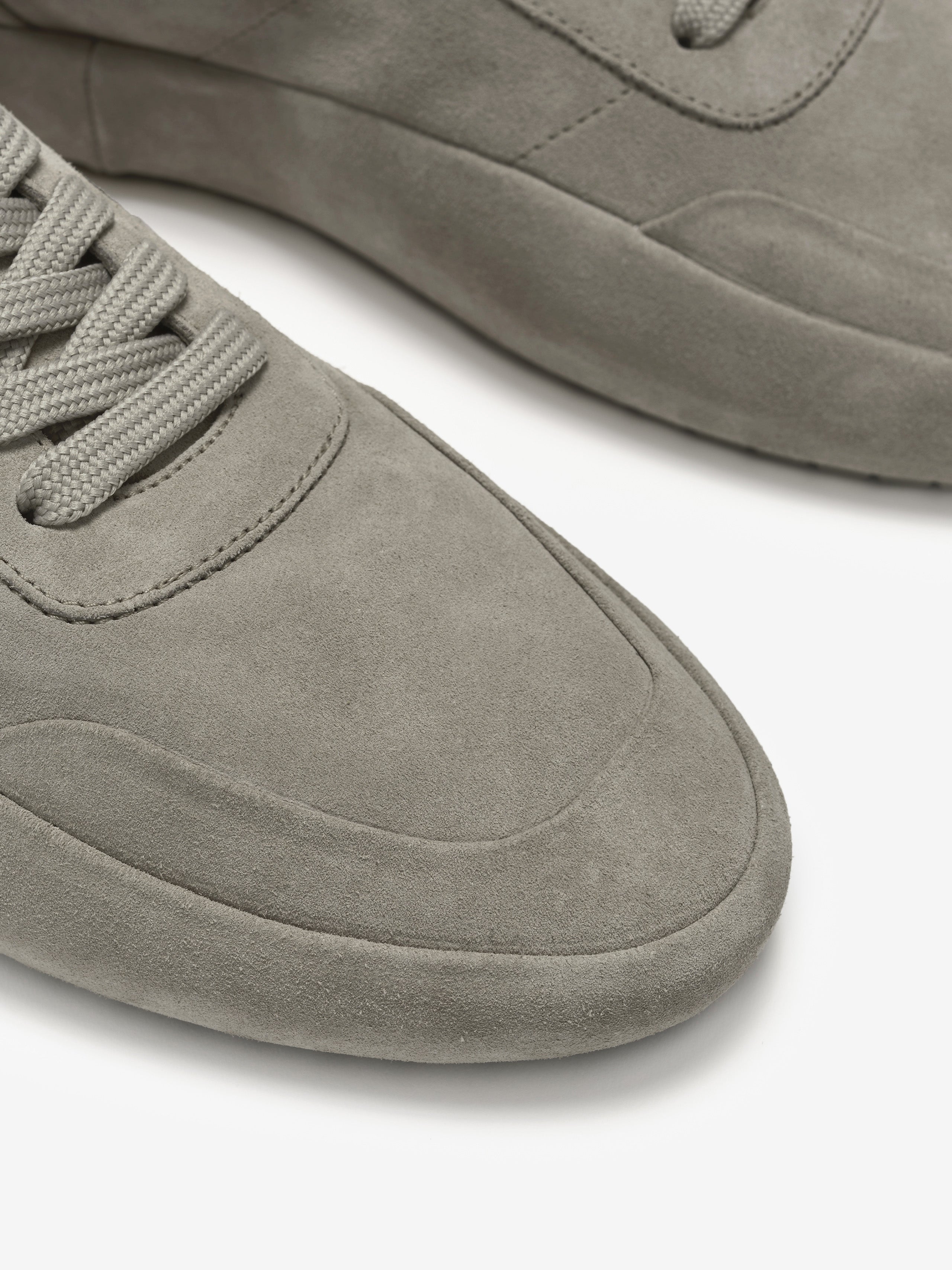 Suede Lace Up Runner in a light grey tone featuring a smooth suede upper with tonal stitching, lace-up closure, and a minimalist rounded toe design for clean modern footwear style.