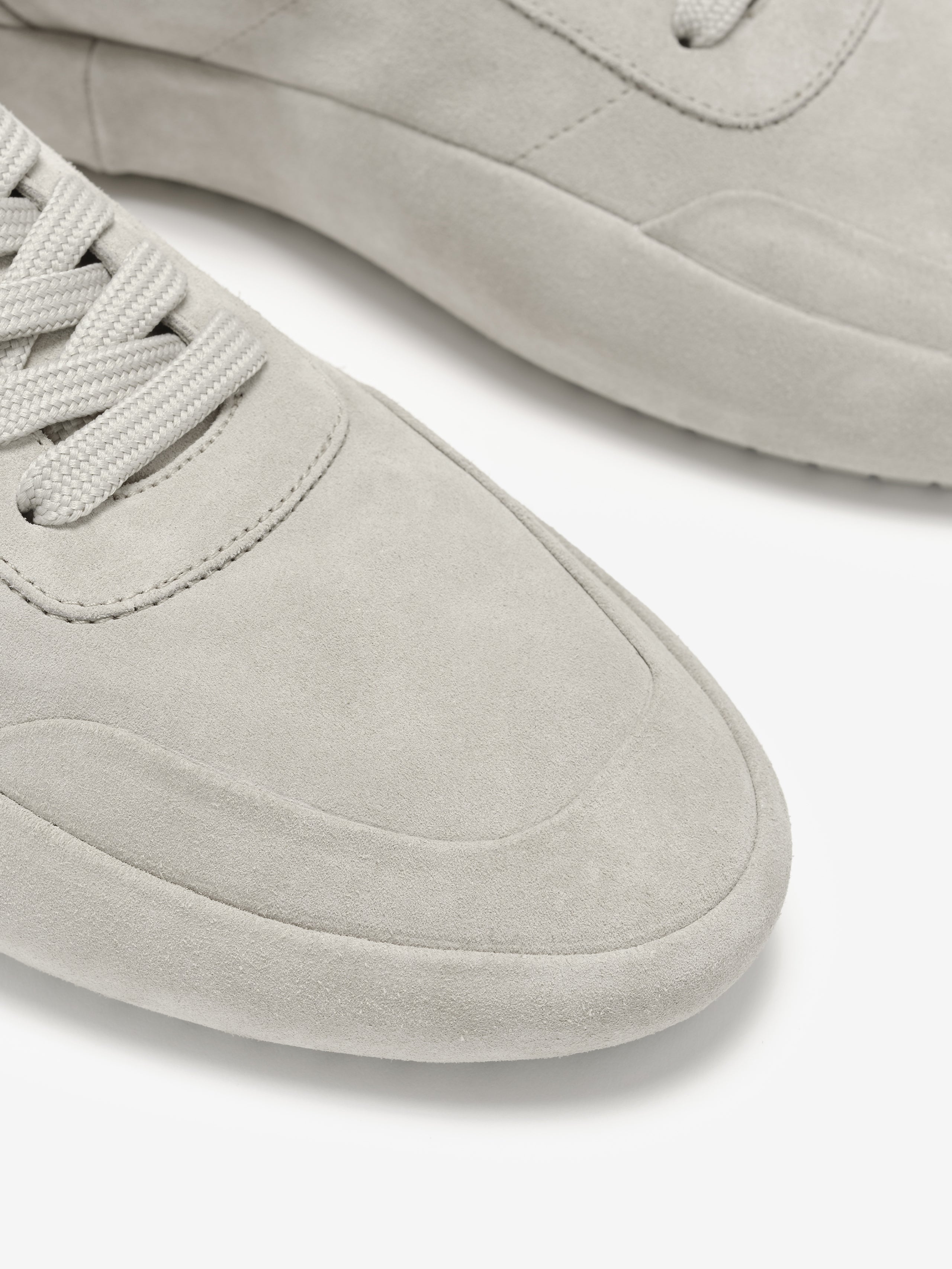 Lace Up Runner in soft light grey suede with a smooth finish, featuring tonal laces and subtle stitch detailing for refined, comfortable everyday footwear.
