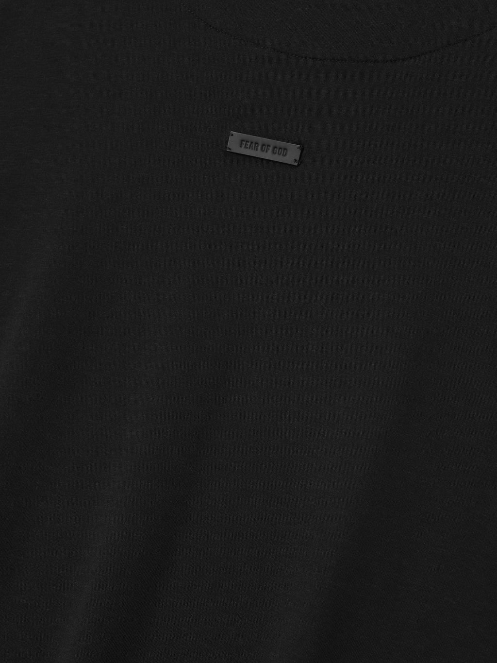 close-up of black cotton-rayon tee with minimal Fear of God label centered below the crew neck