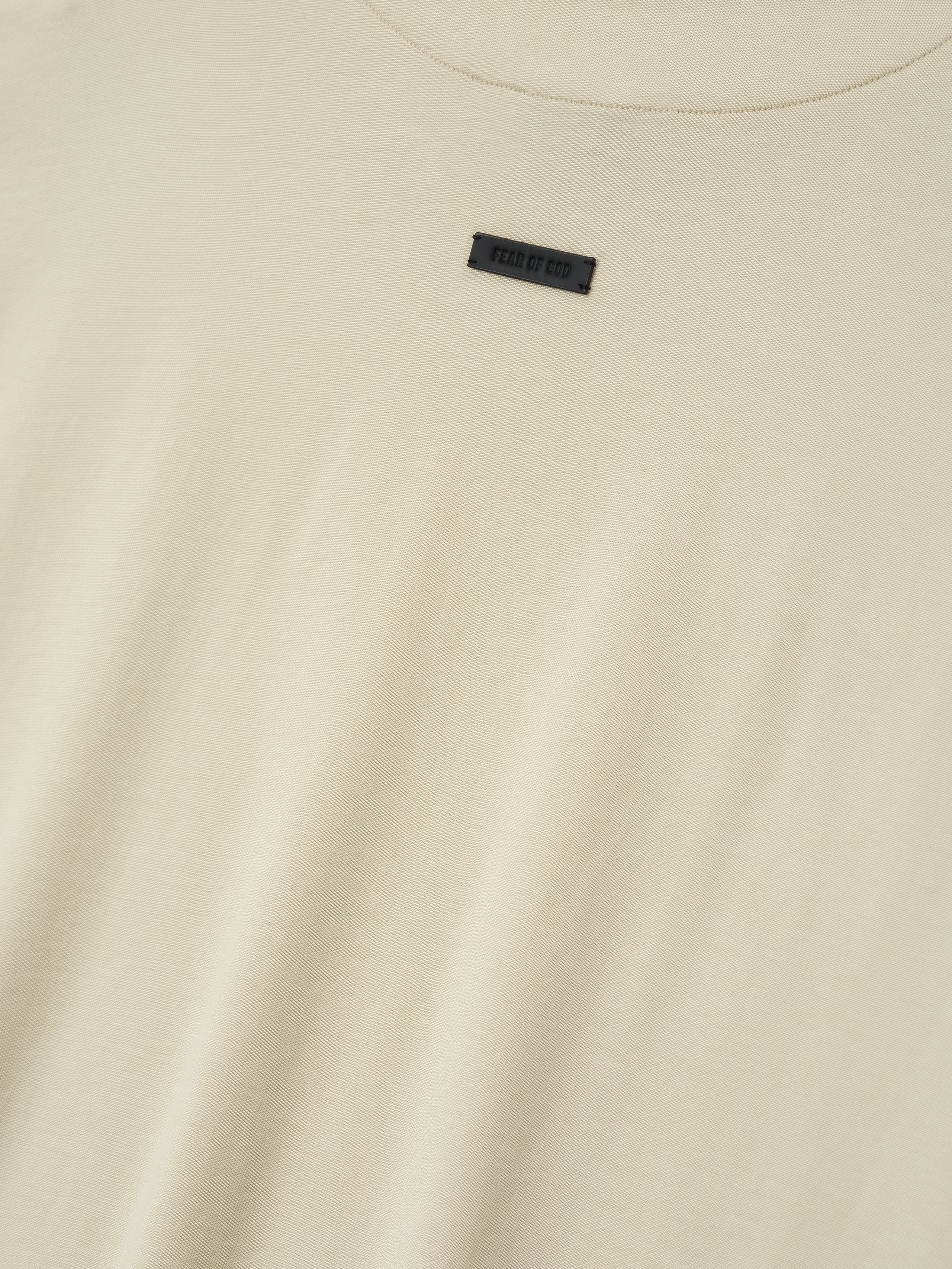 off-white cotton-rayon crew neck tee with soft stone wash and small black Fear of God label centered near neckline
