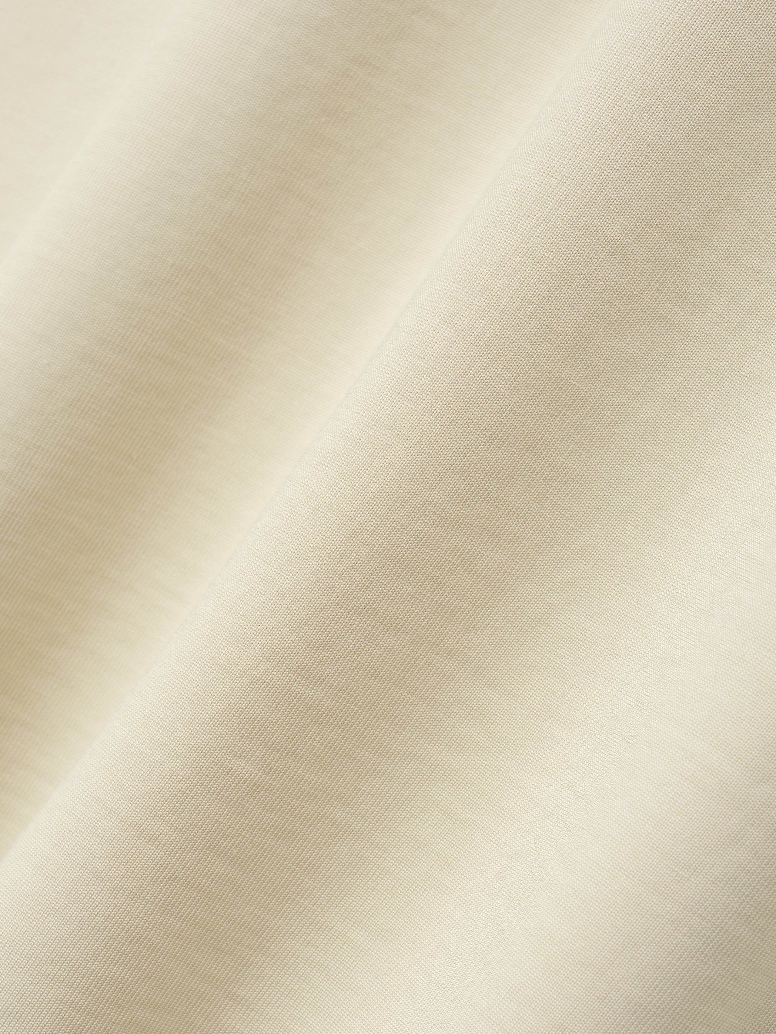 close-up of soft off-white cotton-rayon fabric showing smooth texture and subtle vintage wash effect