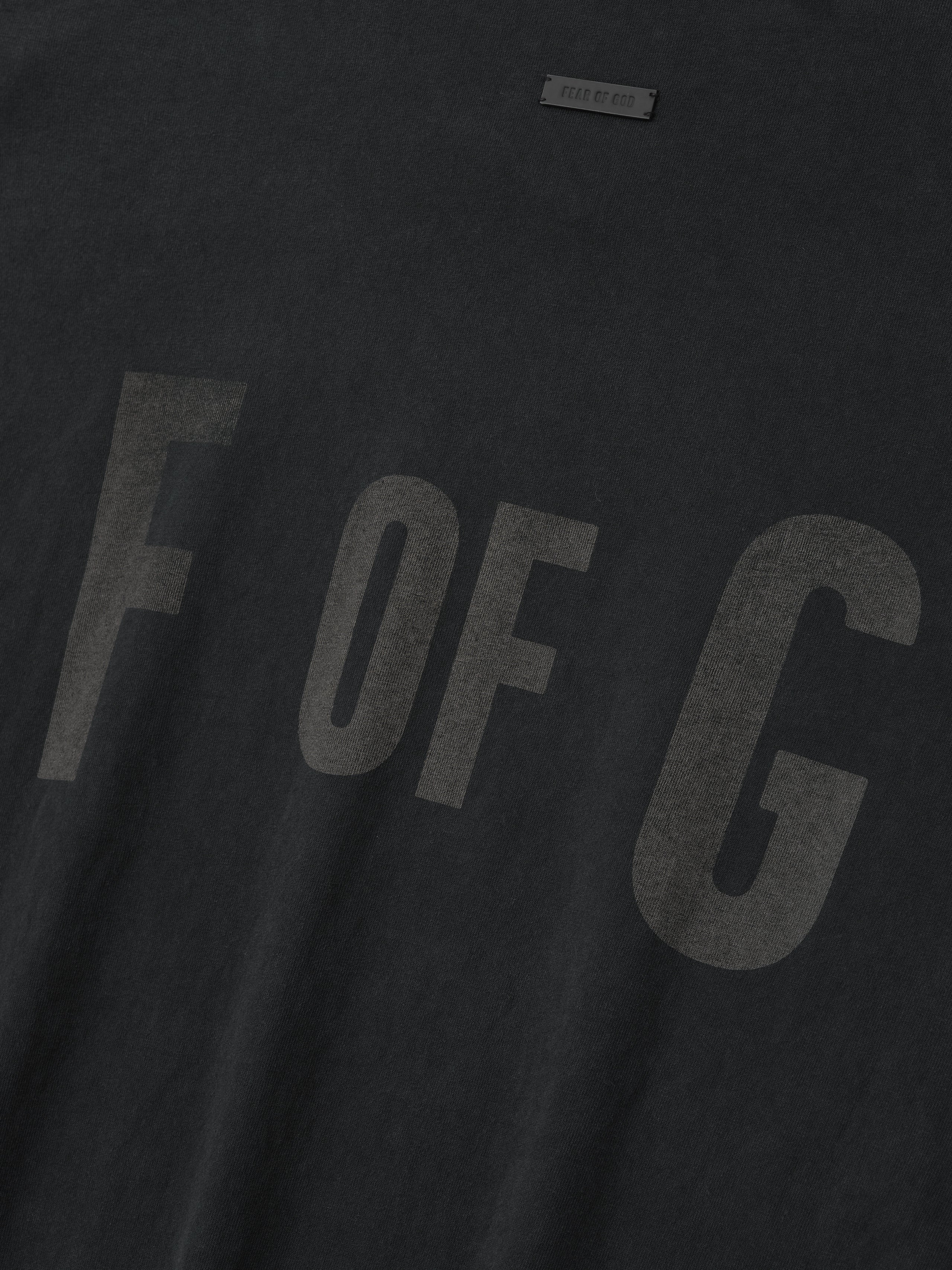close-up of black heavyweight cotton long sleeve tee with subtle faded "F OF G" graphic across the front chest