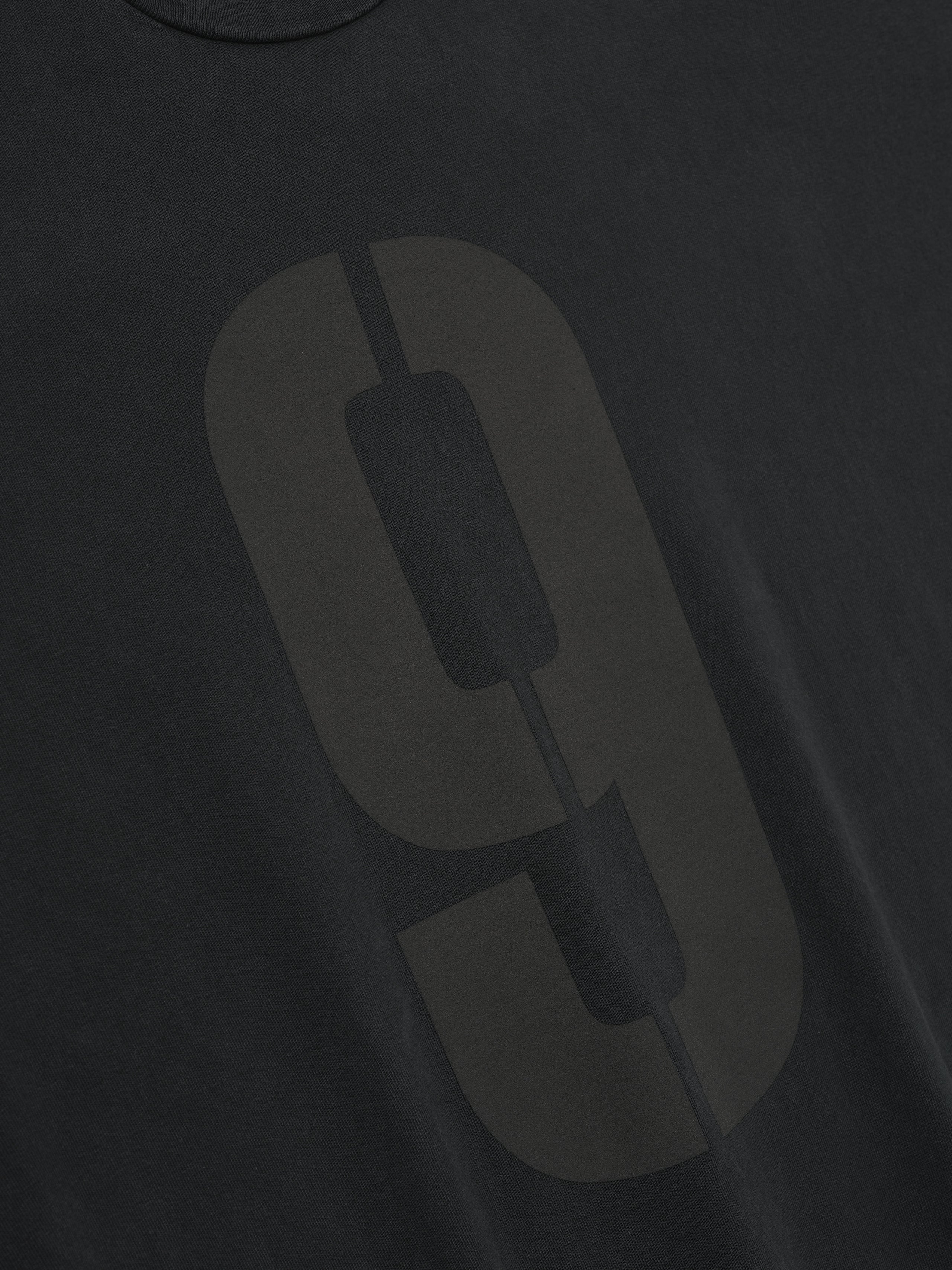 black heavyweight cotton long sleeve tee with large faded number 9 printed in a vertical split design on front chest